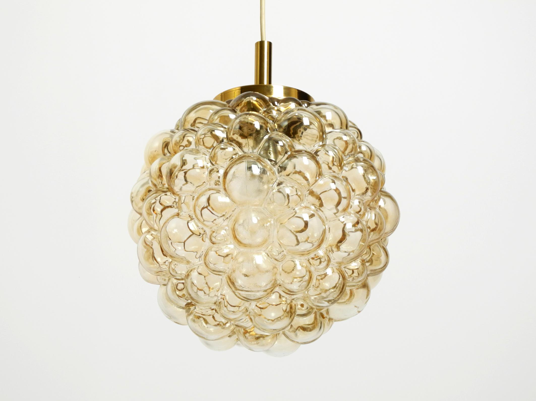 Original glass bubble pendant lamp from the 1960s. Manufactured by Limburg.
Designed by the Finnish glass artist Helena Tynell.
Very good vintage condition with a light patina on the brass.
No damage to the glass or suspension, no cracks or chips on