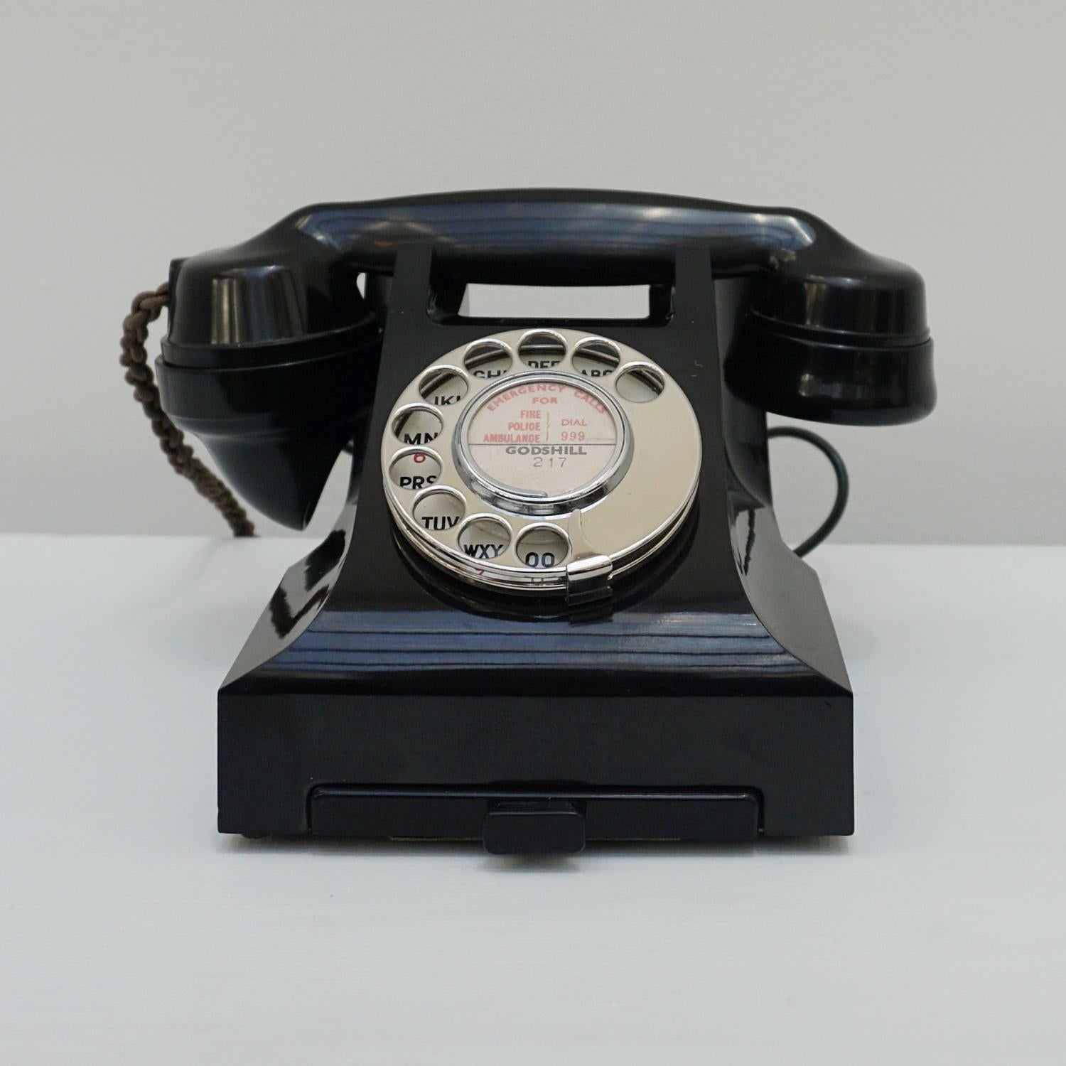 An original GPO model 332L Telephone. Black bakelite with integral drawer and braided handset cord. Registered number to face.

Dimensions: H 15cm, W 20cm, D 16cm

Origin: English

Date: Circa 1950

Item No: G1703228

All of our telephones