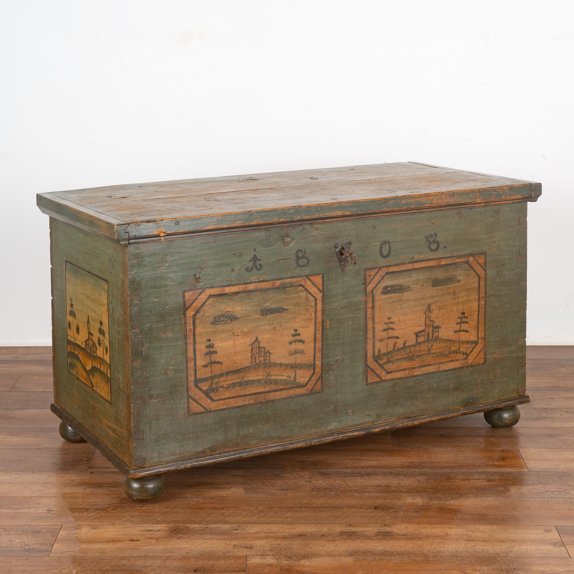 The charm of this original painted trunk comes from the simplistic landscape painting that still graces the front, even after 200 years of use.
Please enlarge photos to appreciate the painted panels, colors (primarily green with blue undertones),