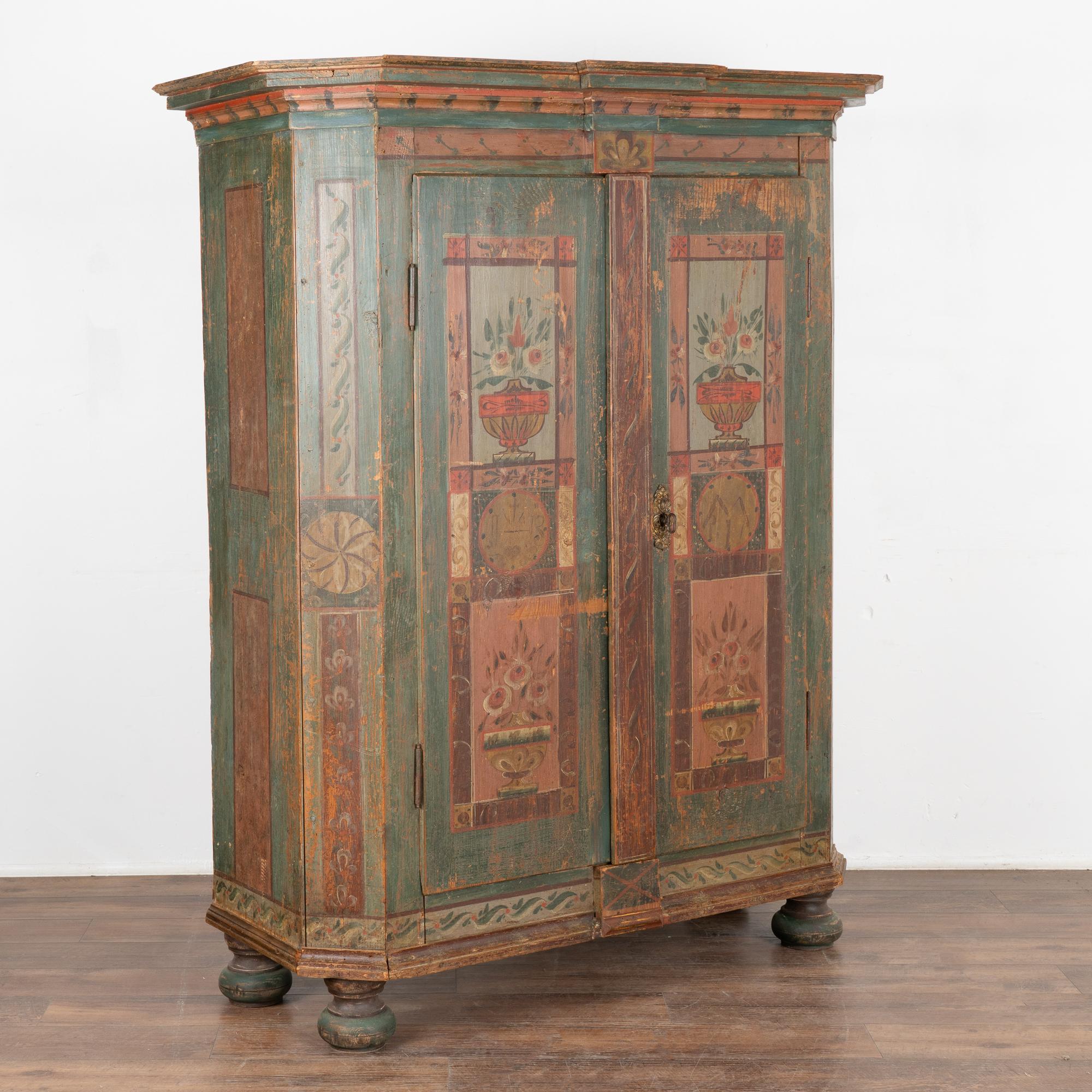 This painted pine armoire still maintains the quality and details of the original hand-painted finish. The floral and geometric patterns against the green painted background were traditional folk art style elements of the era.
This armoire was