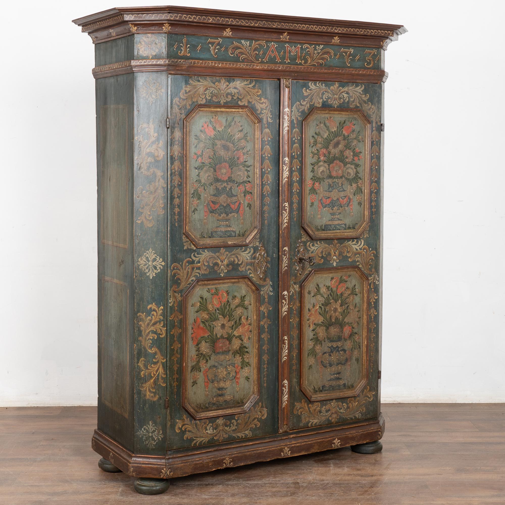 Cette armoire en pin peint conserve la qualité et les détails de la finition originale peinte à la main et la date de 1773 sur la corniche supérieure. Les fioritures étendues et élaborées indiquent qu'un investissement a été réalisé lorsque cette