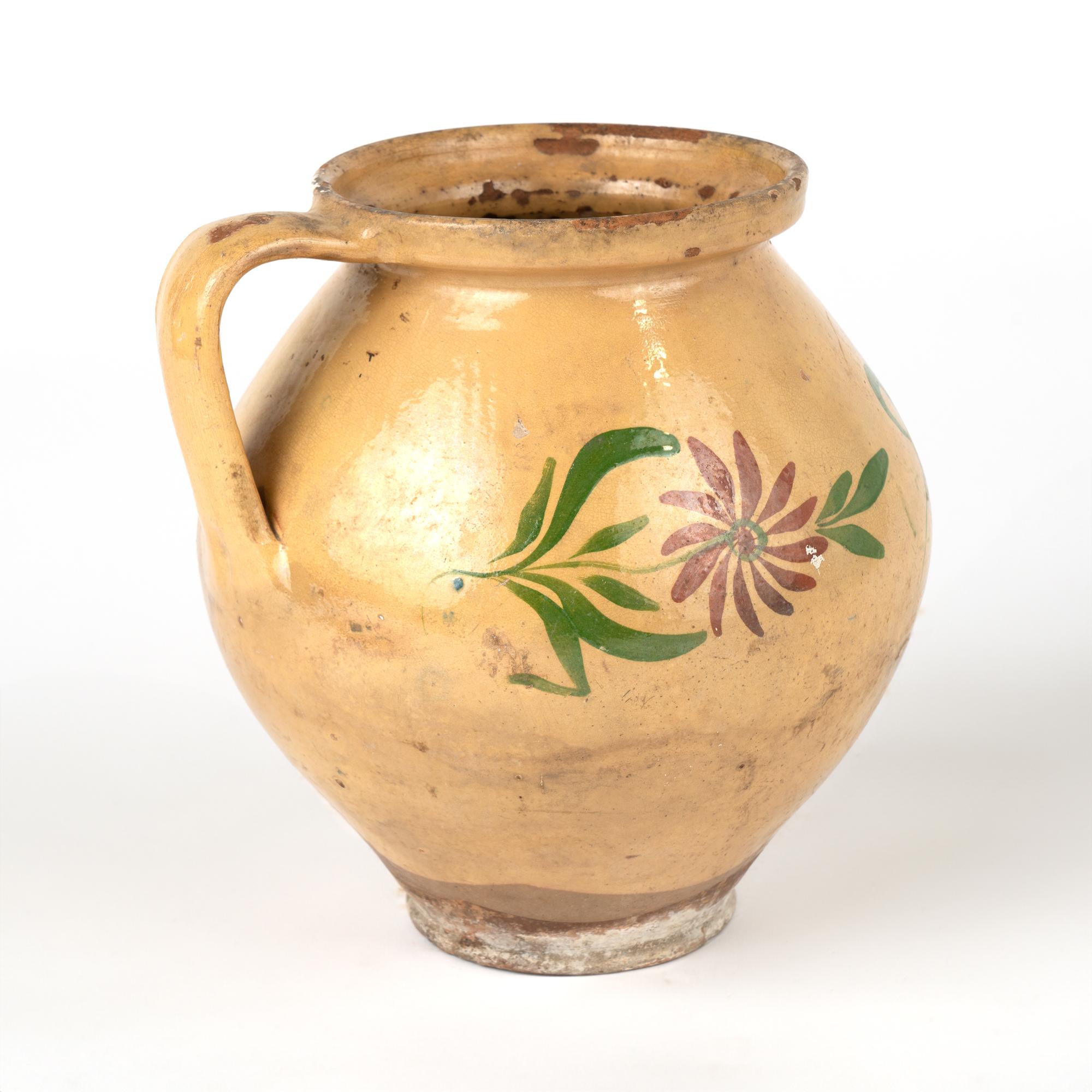 Original hand painted earthenware pottery with handle. Light ochre background with floral and leaf design.
Sold in original vintage used condition. Any chips, cracks, distress to paint or pottery is reflective of age and use. Solid condition.

With