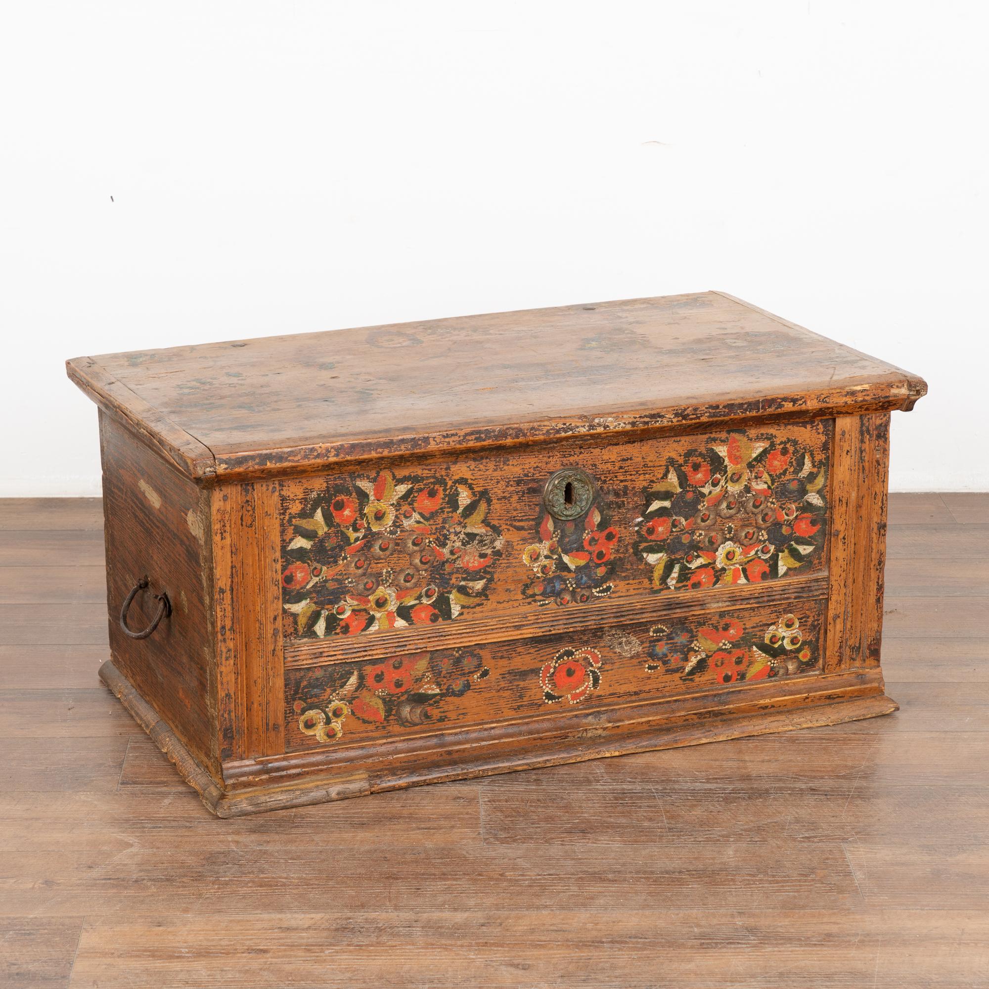 Original hand-painted folk art flat top pine trunk.
Original traditional floral motif painted in brown, orange/reds, brown/black, yellow, white and black.
Restored and waxed, in solid condition ready to use. Original hand-wrought iron hinges and