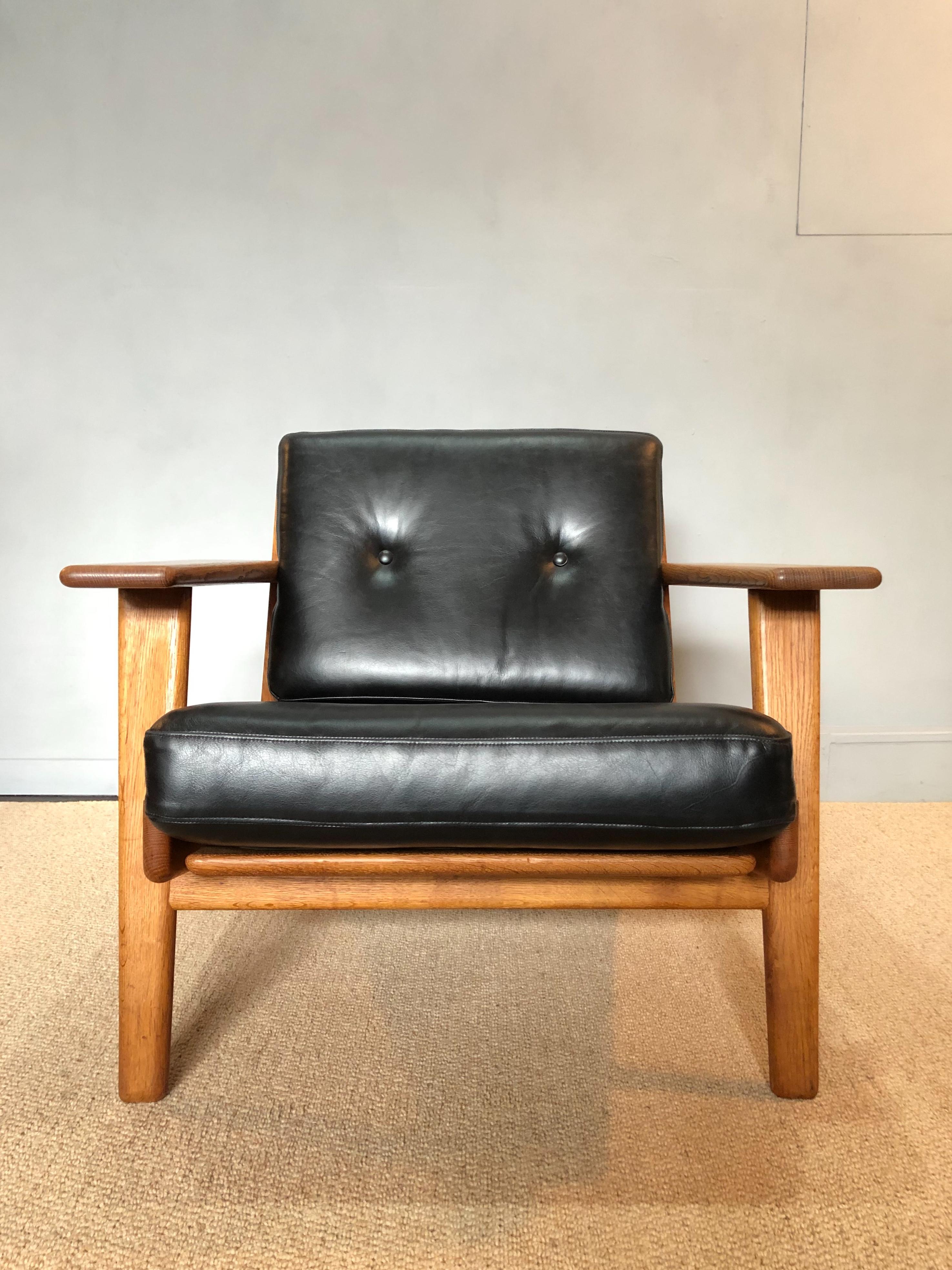 Original 1950s GETAMA ge290 lounge chairs by Hans J Wegner. These chairs have been fully reupholstered in a jet black leather sympathetic to its heritage. European oak frames have been cleaned and re-oiled. Original metal sprung cushions. Original