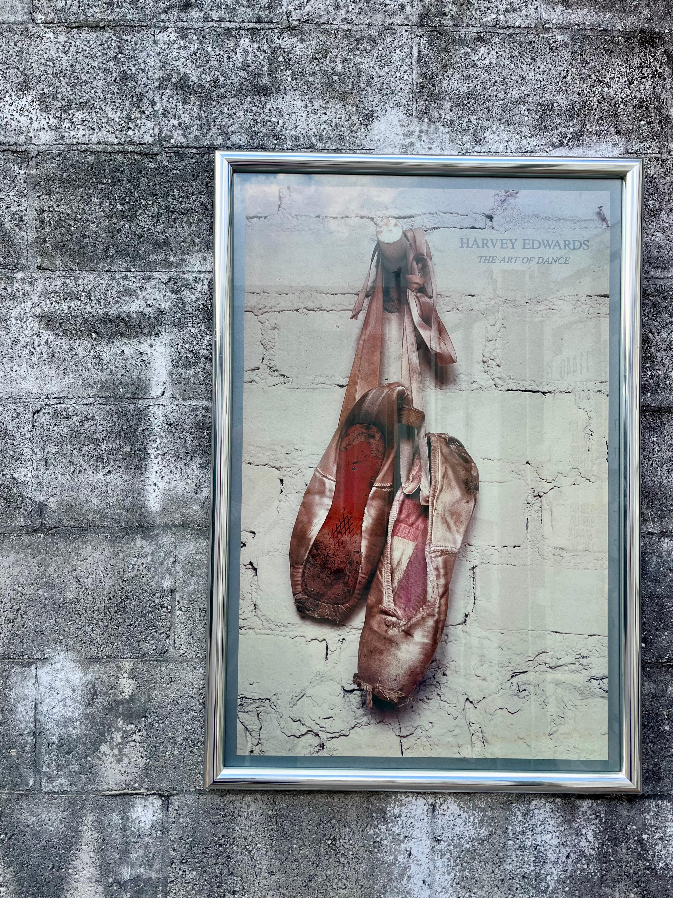 Original Vintage Harvey Edwards' The Art of Dance Framed Poster. Circa 1980s
Features a photograph of a pair of distressed ballet shoes on a brick wall background framed with a polished aluminum frame and protected with glass. 
In good original