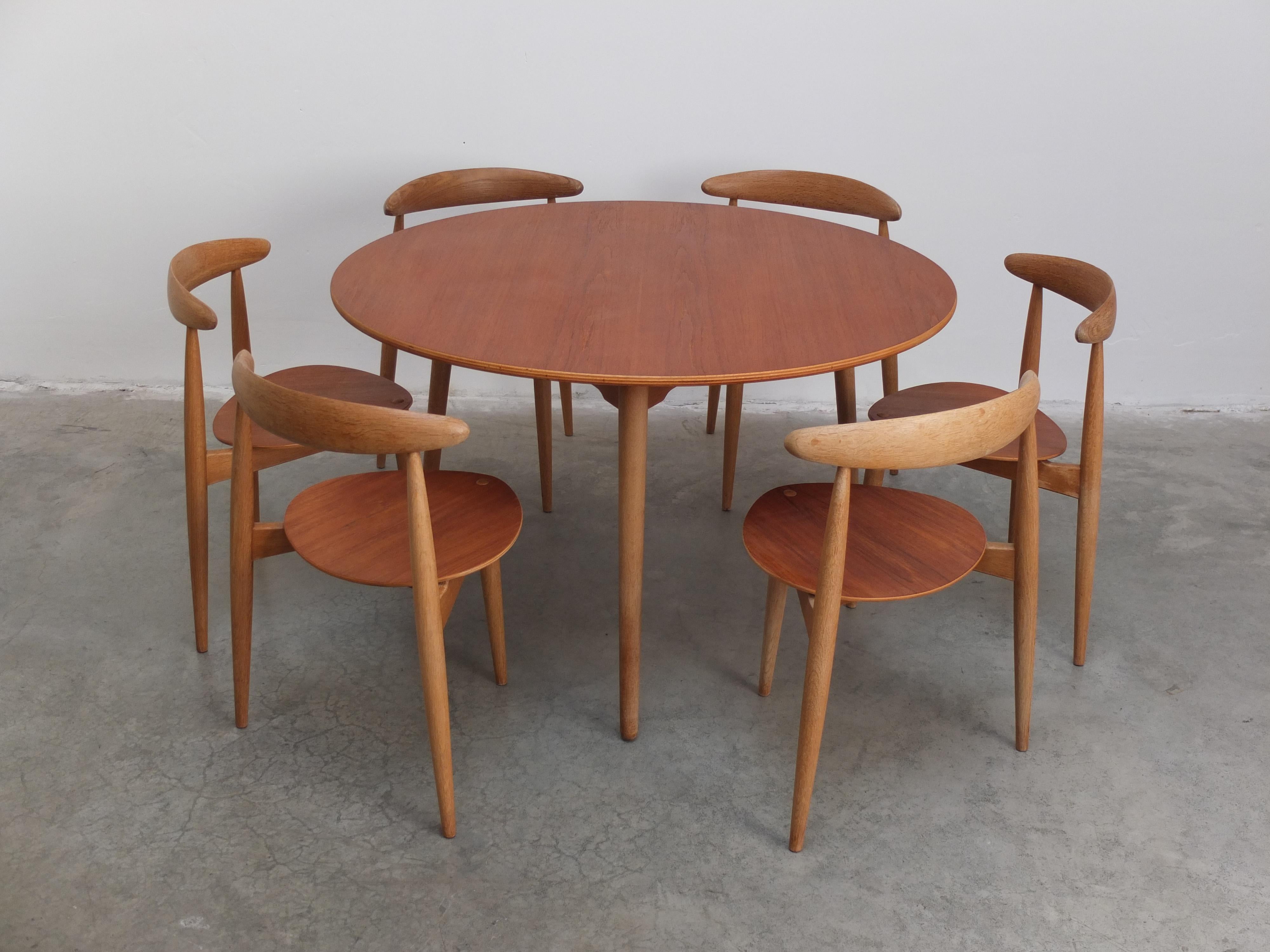 Original ‘Heart’ dining set designed by the godfather of Danish design, Hans J. Wegner in 1952. It consists of a 3 legged table (FH4602) with 6 stackable 'Heart' chairs (FH4103). The legs are made of solid oak combined with a teak table top and