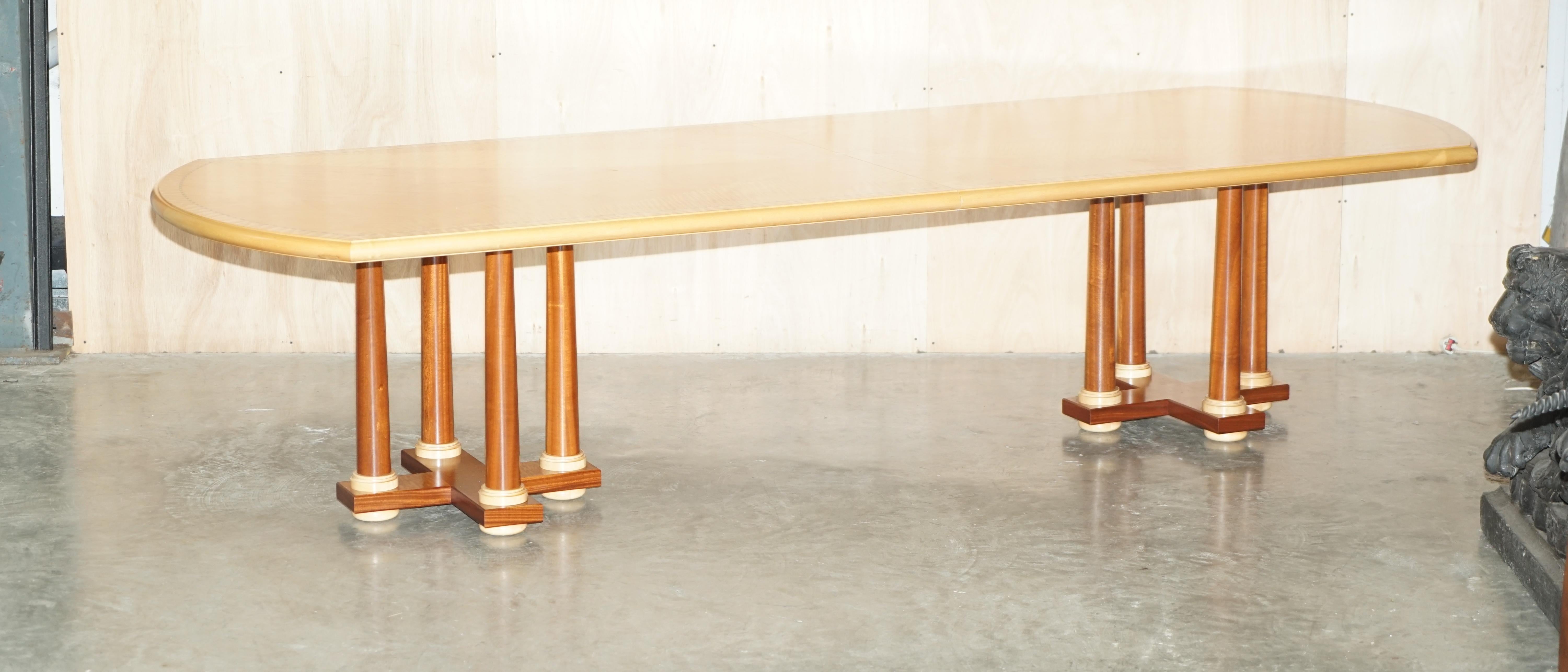 Wir freuen uns, diesen erhabenen Designer Andrew Varah 12-14 Personen, Satinholz mit Perlmuttintarsien, extra großen Esstisch mit korinthischen Säulenbeinen, der Teil einer Suite ist, zum Verkauf anzubieten.

Bitte beachten Sie die Liefergebühr