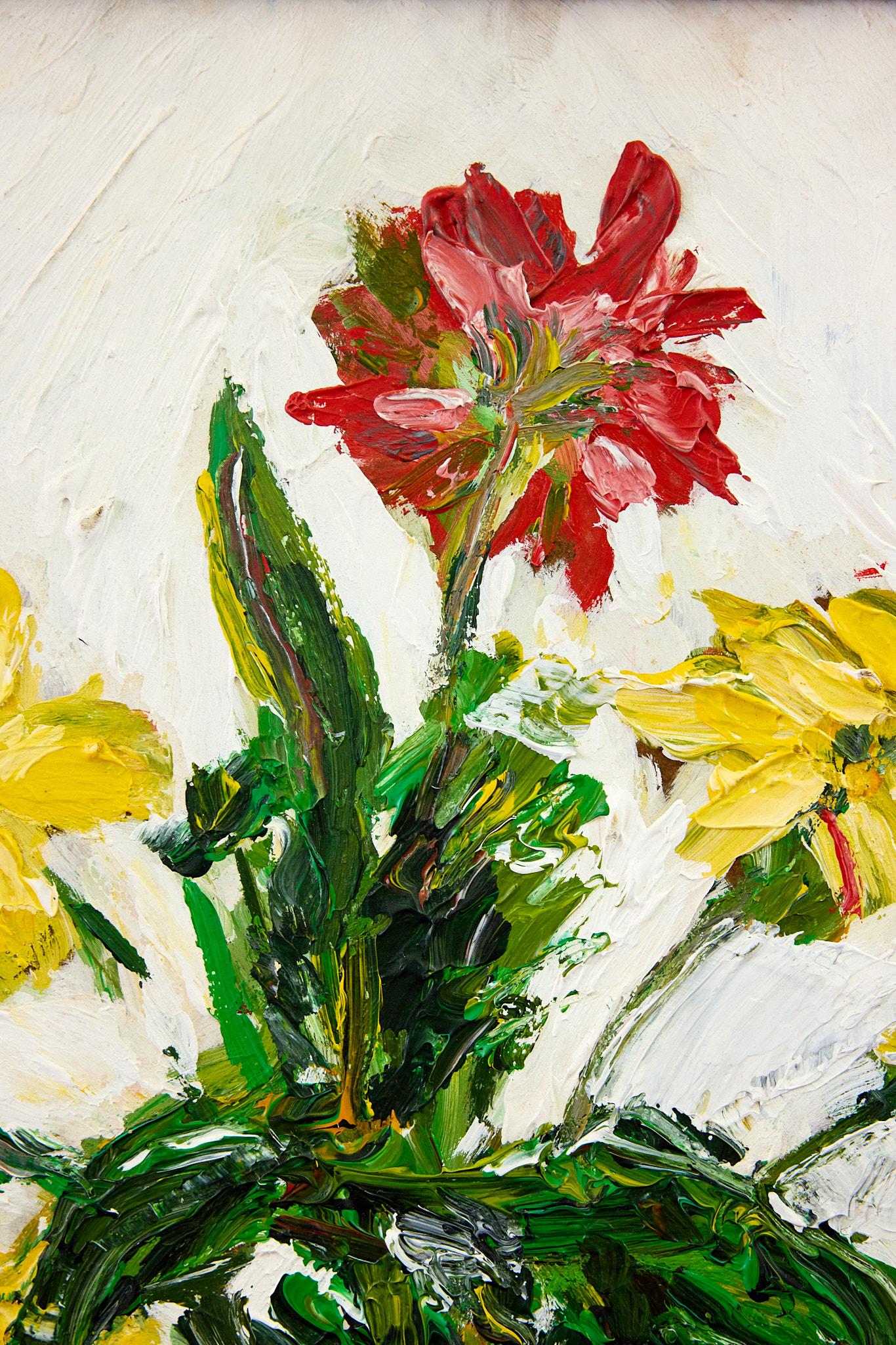 Bold and bright 20th Century Impressionistic floral still-life painting of a clear glass vase holding a bouquet of red and yellow stemmed flowers against a white backdrop. 

The oil on board original painting is unsigned and framed in a red, ribbed 