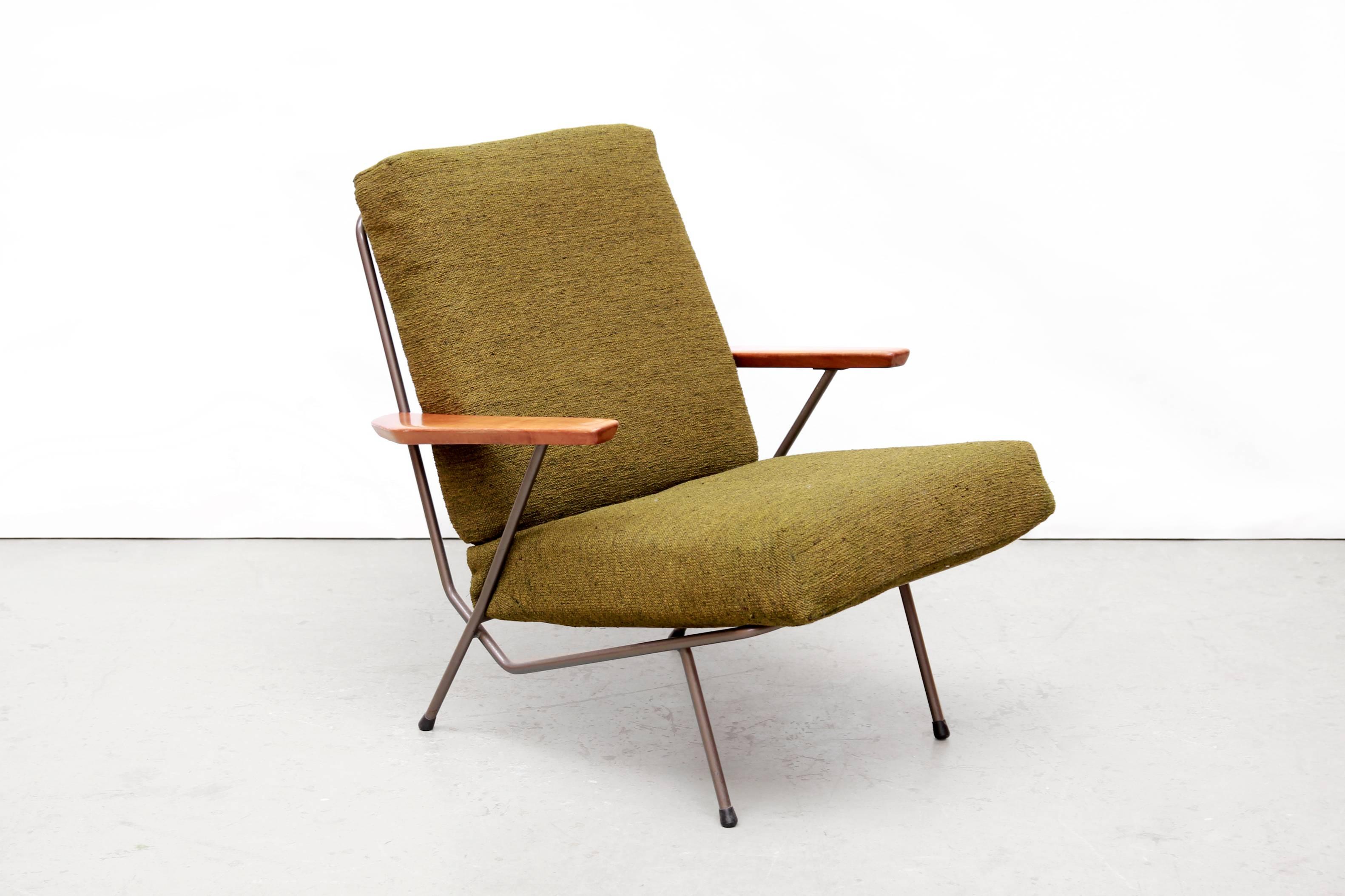 This Dutch design armchair was designed by Koene Oberman for Gelderland, the Netherlands around 1954. This Minimalist design with metal frame, wooden armrests and green upholstered spring pillows is an original early vintage edition with minimal
