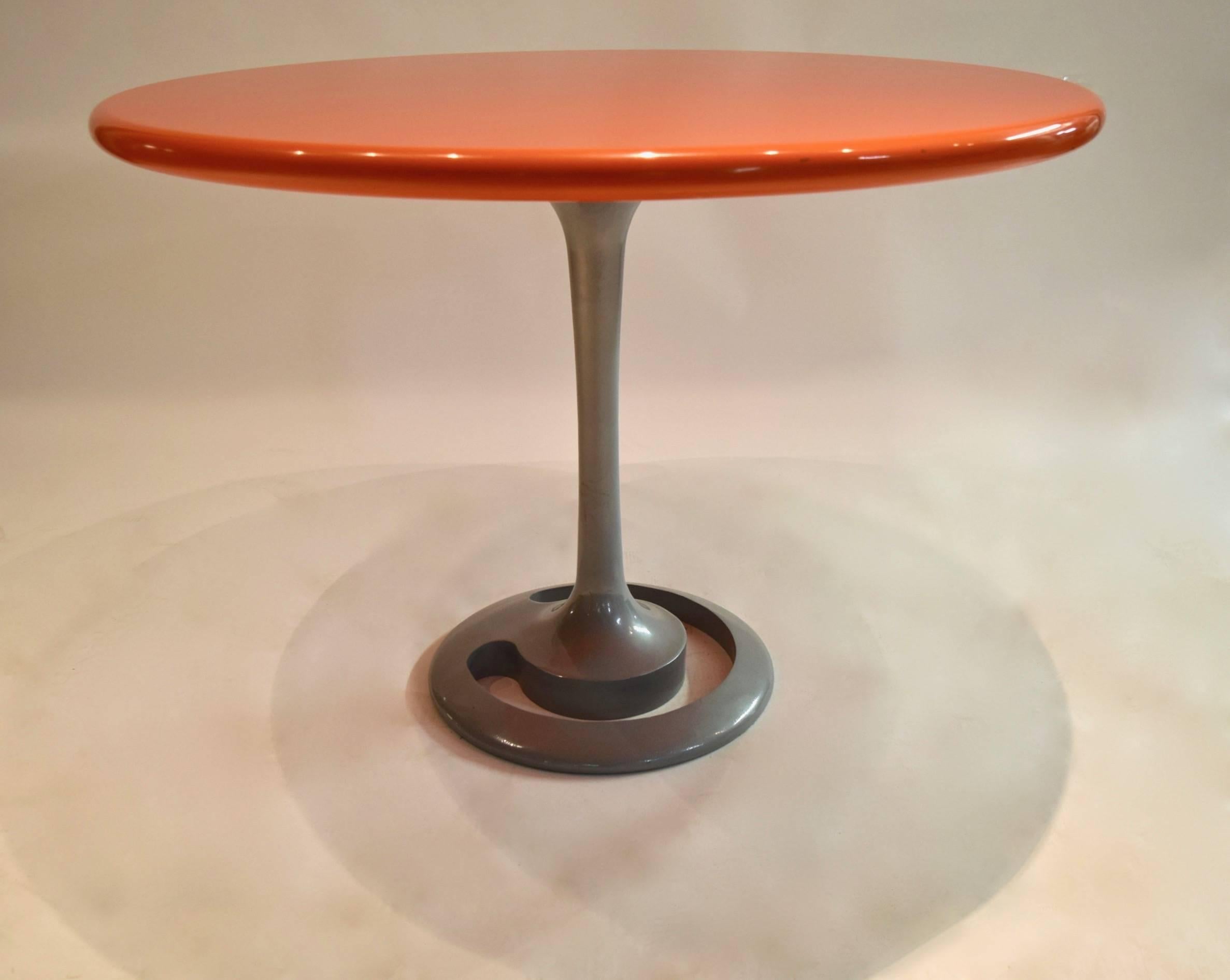 Original, round Komed dining table designed by Marc Newson and made for the restaurant 'Canteen' of New York City that opened in 1999. The table comprises a rounded edged top of thick, orange gloss lacquered wood and a gray-finished cast aluminium