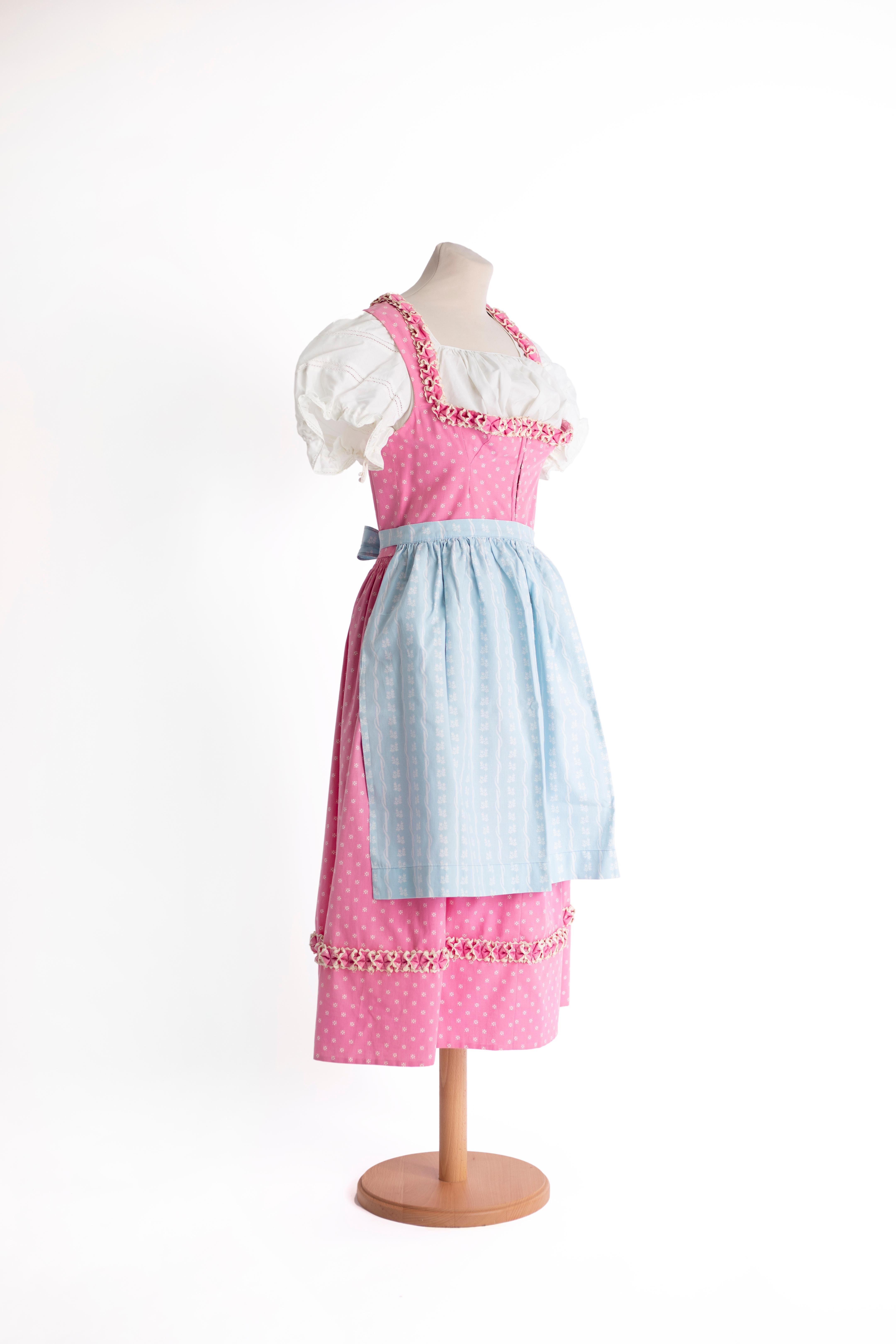 SPECIAL HOLIDAY PRICE: Dirndl made in Austria. Low-cut dress with trimmings on the neckline and on the hem of the skirt. Elasticated waist. Corset style closure. Two different short shirts and a matching blue apron.

Size IT: S
Size USA: