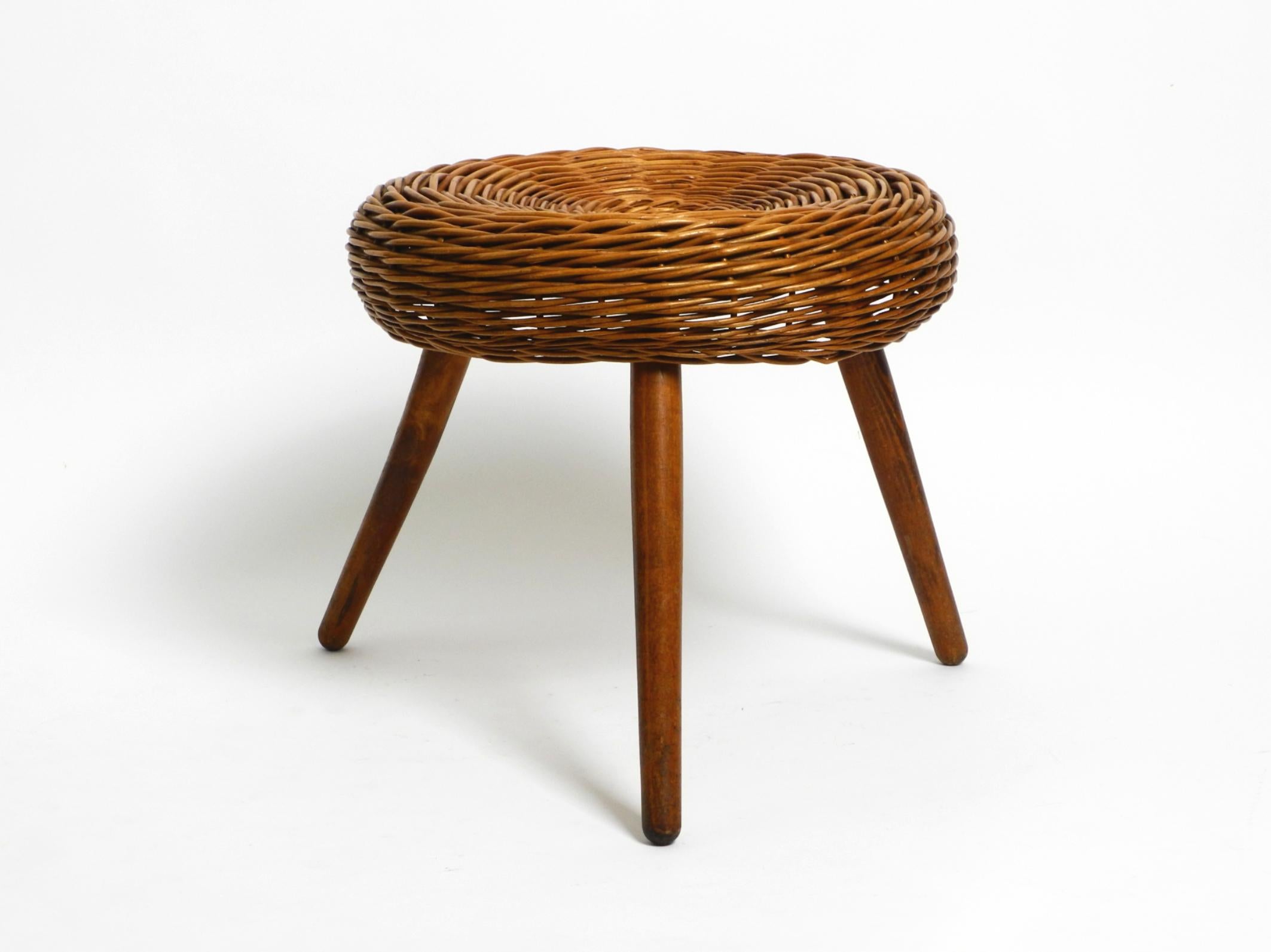 Original large Mid Century Modern rattan stool with wooden legs.
Designed by Tony Paul. Tony Paul was a world-renowned American industrial designer.
He designed furniture, lamps, tableware and much more. His work can be found from the 50s and