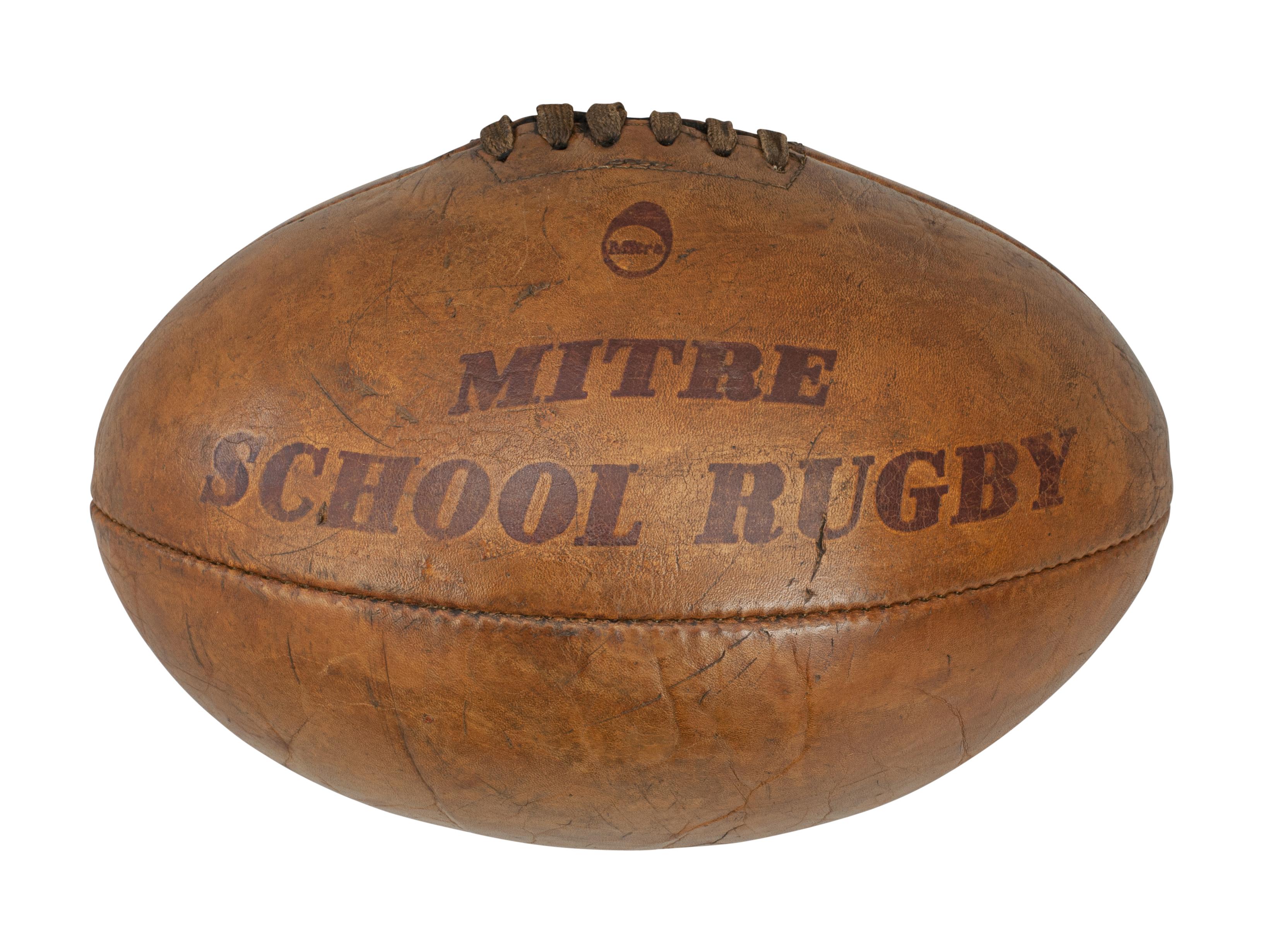 Vintage leather rugby ball.
A traditional Mitre No. 5 leather rugby ball with a lace-up slit to the top and valve for bladder inflation. The ball is with good tan brown colour. A nice four panel rugby ball embossed ' Mitre School Rugby' & the size
