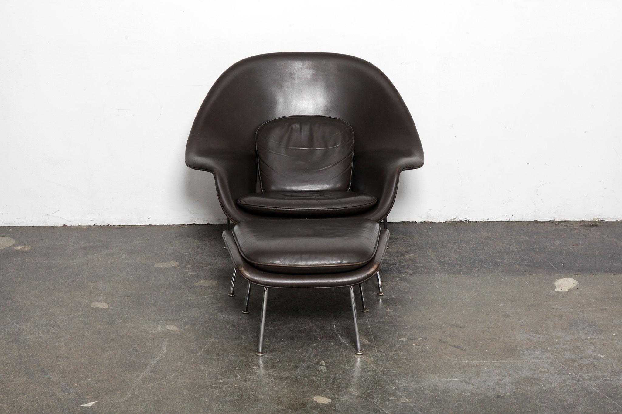 Vintage original grey brown leather 'Womb' chair and ottoman by Eero Saarinen for Knoll, produced in 2001. Leather shows patina/wear commensurate with age. Ottoman measures: 25 W x 21 D, x 14 H

 