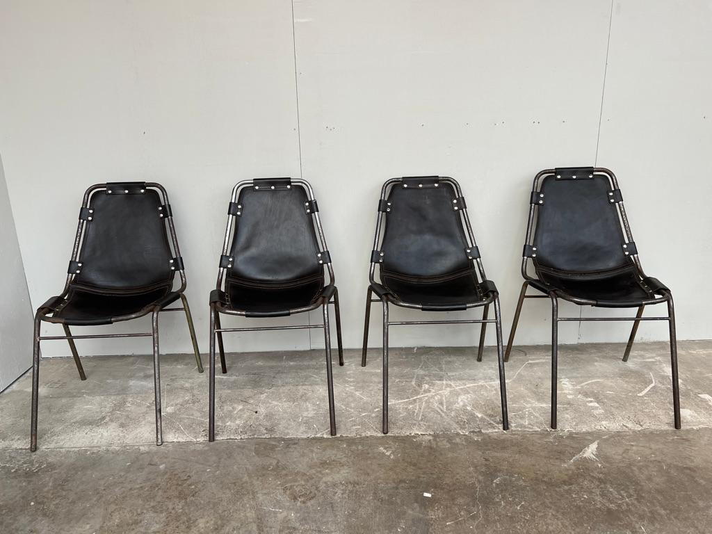 Stunning set of chairs, very vintage, lots and lots of patina on the frames,  lovely Architectural chairs designed by Charlotte Perriand for and used in the Ski Resort Les Arcs, circa 1960. 

These chairs were commissioned to be made by DalVera.