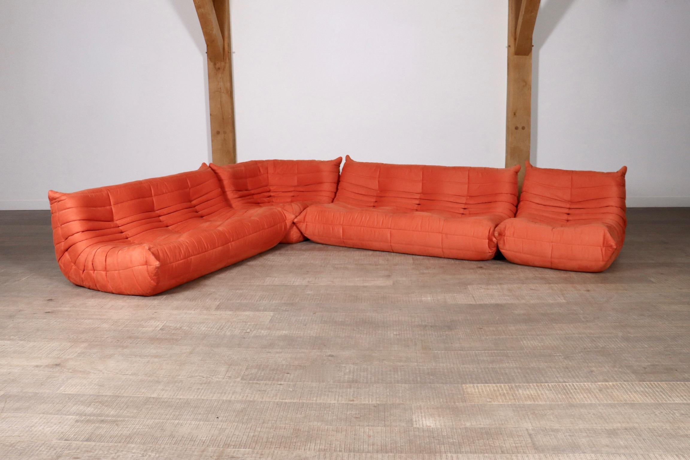 Amazing coral alcantara Togo seating group by Michel Ducaroy for Ligne Roset. The entire seating group has the original Ligne Roset logo and bottoms. The set consists of two 3-seaters, a corner and a lounge chair. The beautiful bright coral colour