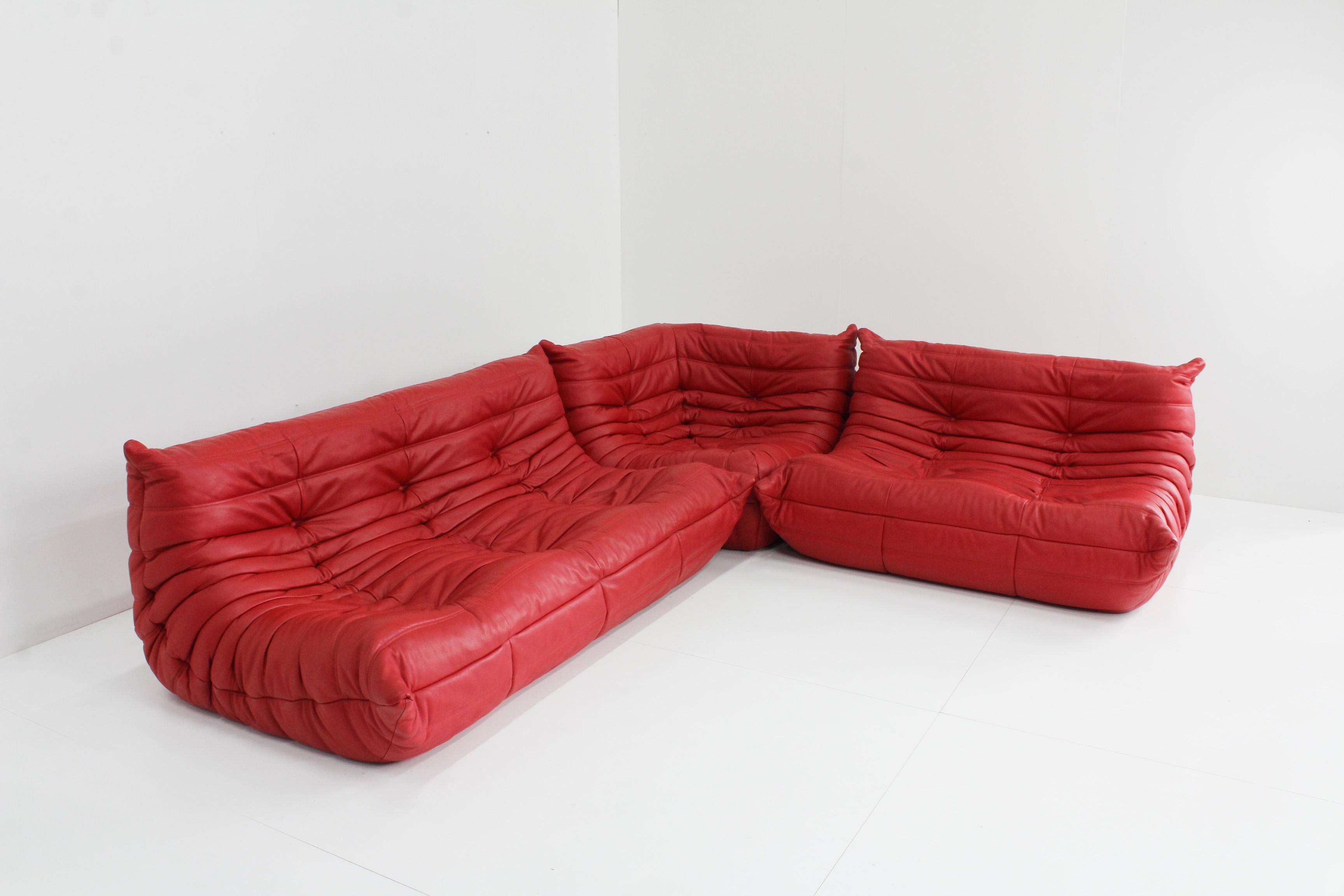 Original red leather Togo sofa set from Ligne Roset by Michel Ducaroy. This is an original piece in high quality leather. 

The sets consist of a 3 seater, 2 seater and corner. 

Condition: very good condition, on the entire set there is one
