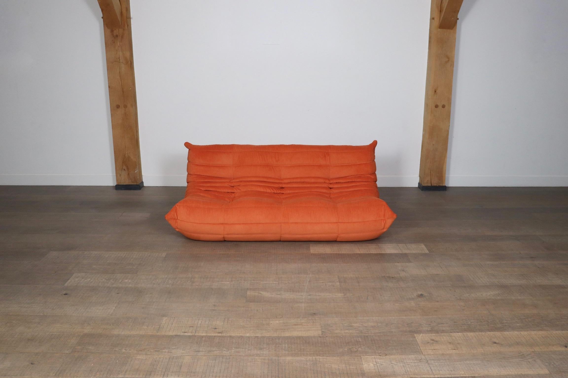 Beautiful Ligne Roset Togo three seater sofa in original coral upholstery by Michel Ducaroy, 1970s. This iconic design has become more and more popular over the years. The lightweight design combined with fun colors and materials make these seating