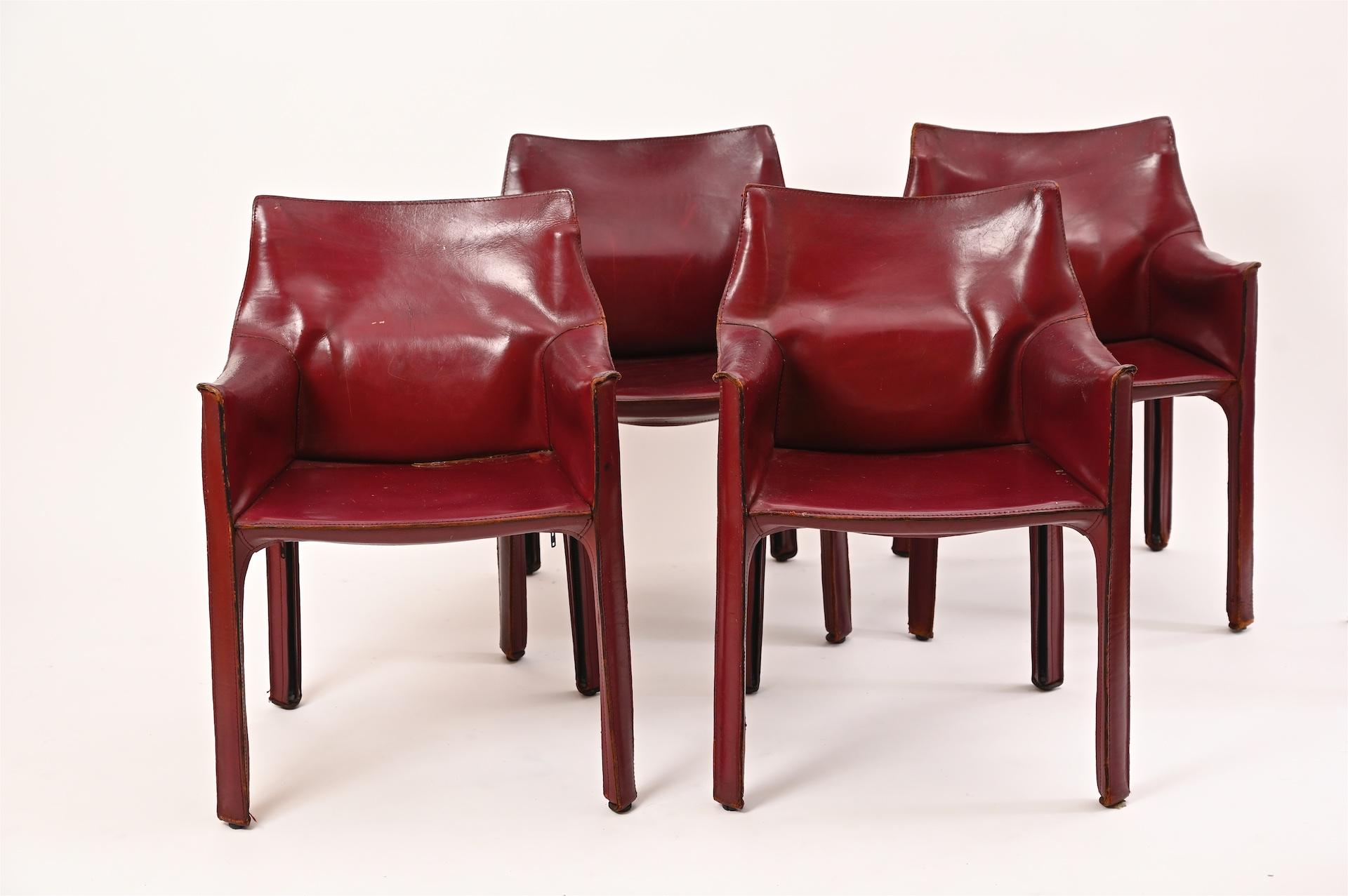 Four original Mario Bellini for Cassina Cab armchairs in Burgundy red.

Stitched leather with zips over steel frame structure.

Leather is nicely worn with good patina.

Some marks and scratches to leather. No tears. Structurally sound. And