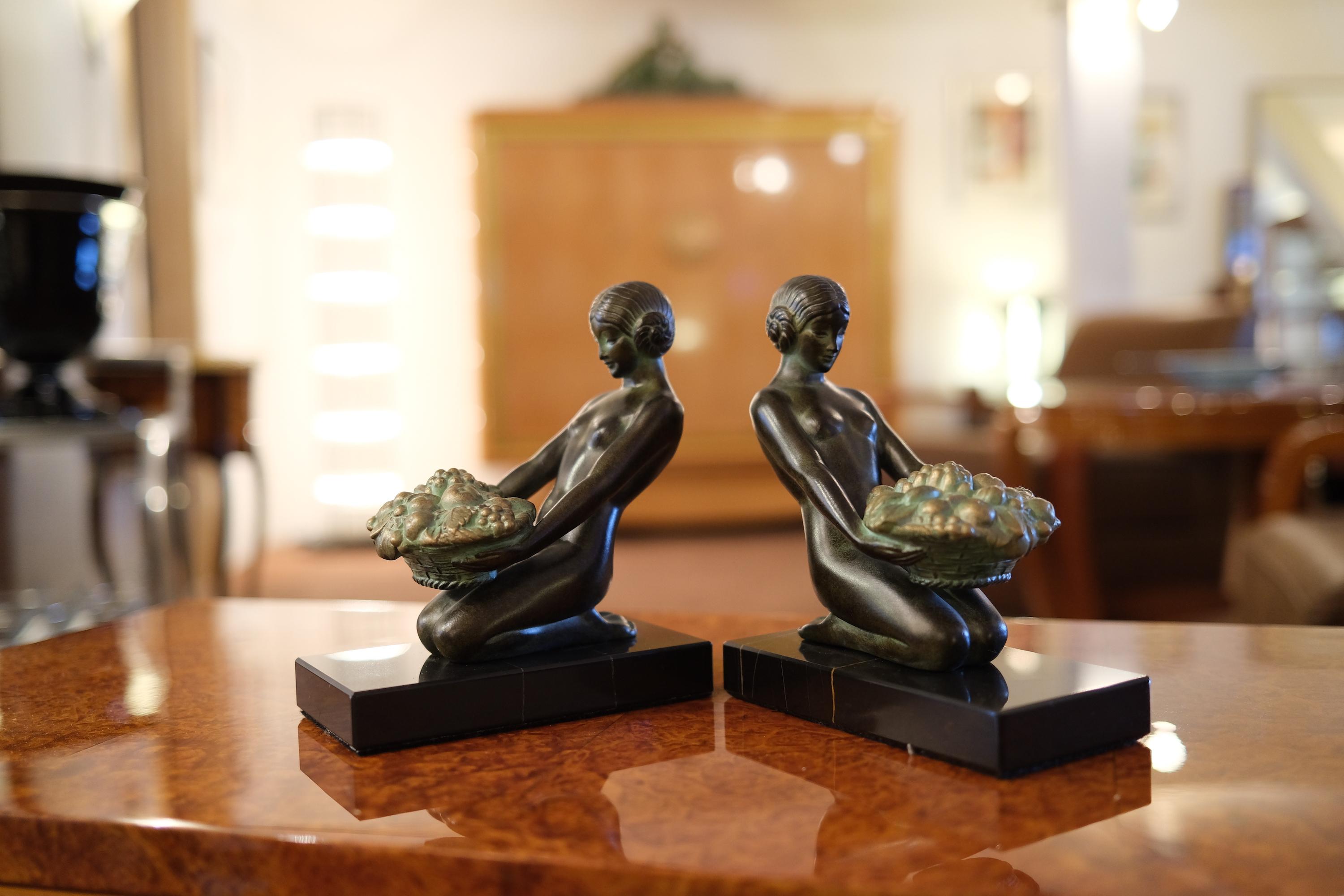 “Cueillette”
Original “Max Le Verrier”
Art Deco style, France.

Ladies with flower baskets 
Bookends made in “Régule” (spelter / whitebronze)
signed

Socle in black stone (could have a different marbleization than the picture) 
Green patina