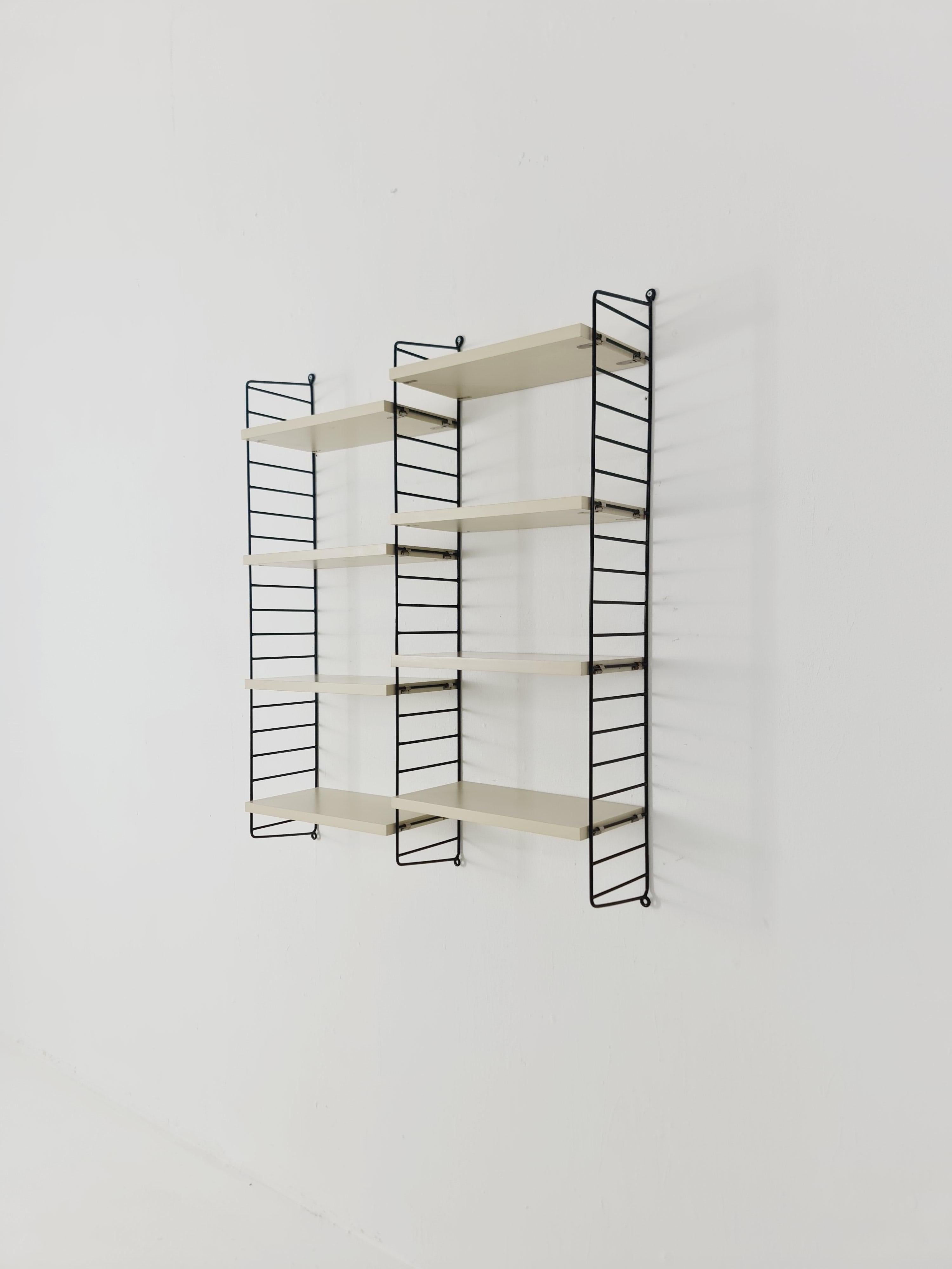 MCM Holzregalsystem - besteht aus schwarz lackierten Metallleitern, von string Stockholm. 

Die jeweiligen Elemente sind aus Holz gefertigt. Neben Regalen, abschließbaren Fächern und Platz für Bücher verfügt das System über einen Schreibtisch mit