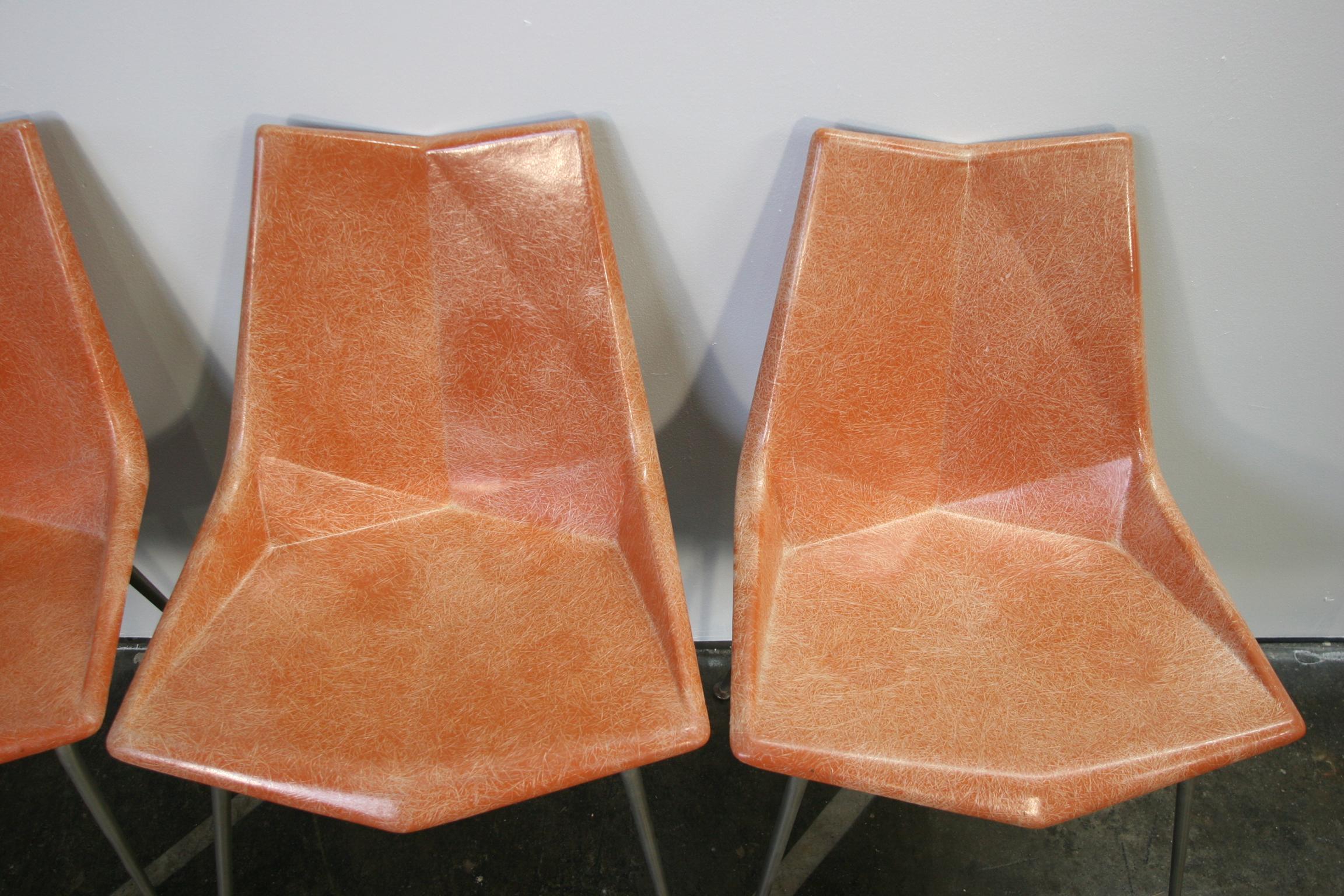 Set of four original midcentury orange Paul McCobb origami fiberglass with reinforced plastic has brushed steel bases. All four of these side chairs are marked Paul McCobb by St. John Seating Corp. New York. Very rare set.