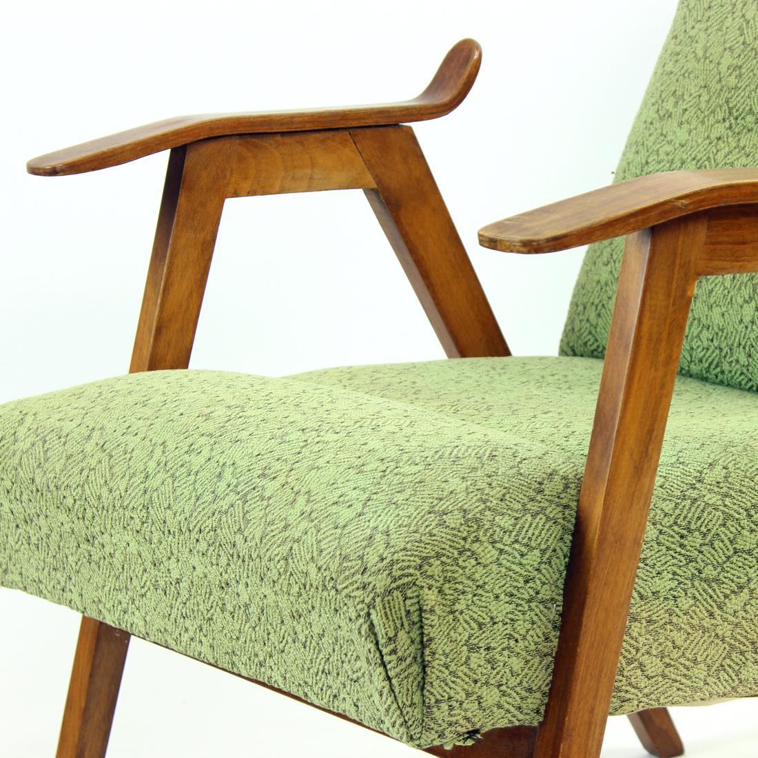 Beautiful mid-century armchair. Produced in 1960s by Mier company in Czechoslovakia. The chair has restored wooden parts which are finished in a natural shade and finish of the oak wood. The seat is upholstered in an original fabric in green shade
