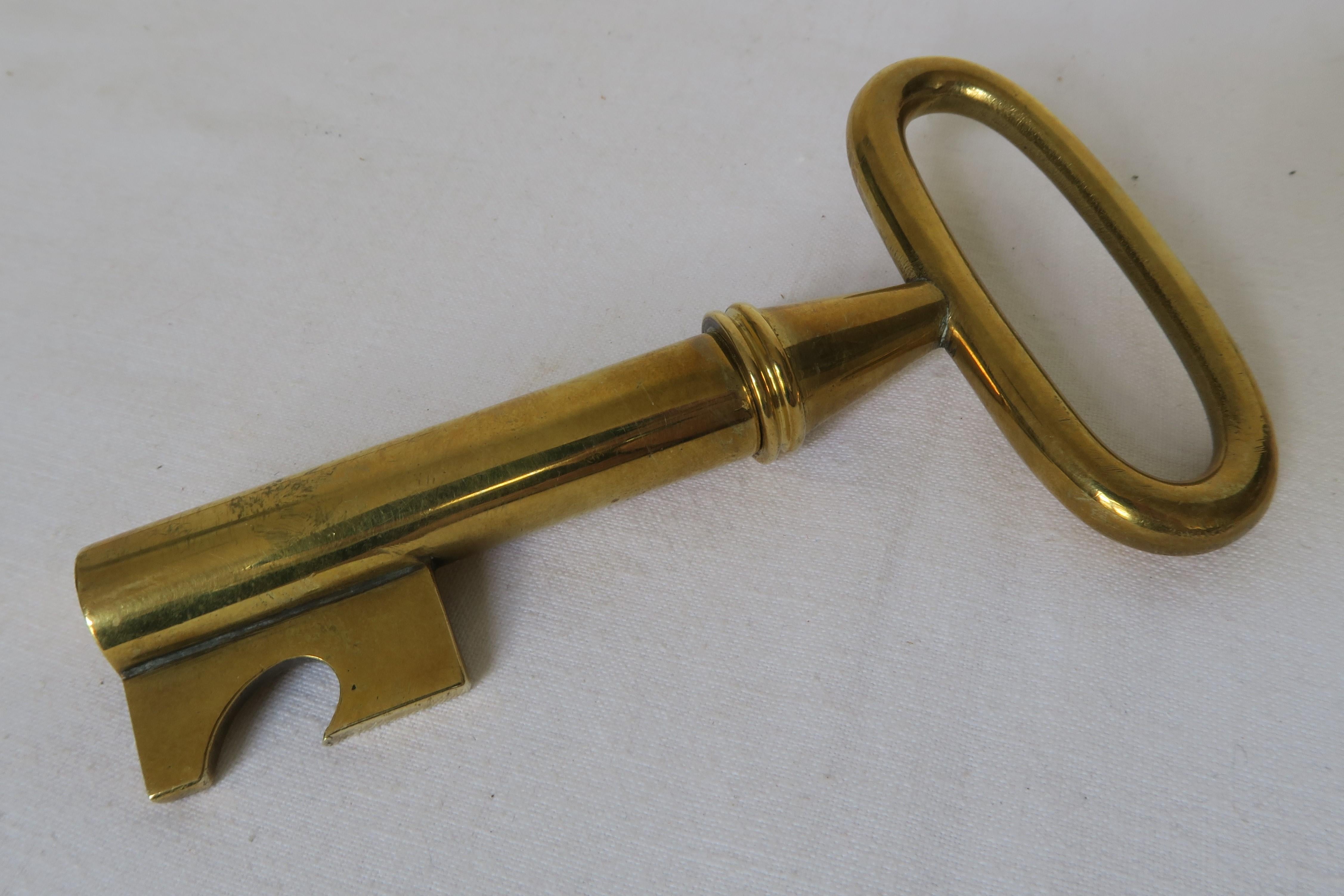 For sale is a beautiful bottle opener and cork screw in key shape. It was crafted from brass and designed by the renowned workshops of Carl Auböck in Austria. The item represents the typical reduced style of the 50s and German Bauhaus, where Auböck