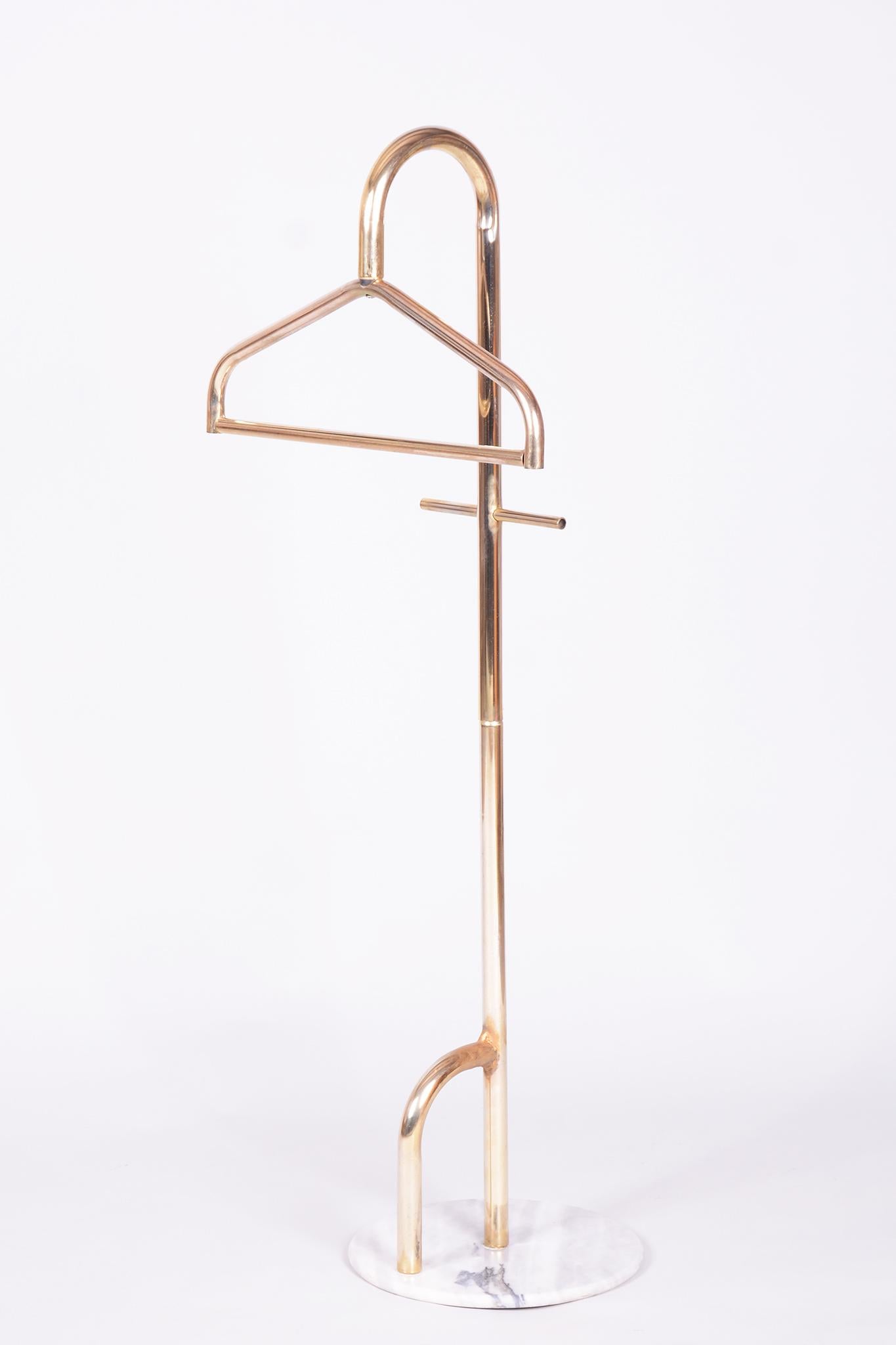 Este elegante aparcacoches de mediados de siglo procede de Francia, de la segunda mitad del siglo XX. Su diseño se caracteriza por una combinación atemporal de materiales y funcionalidad.

La estructura es de latón y descansa sobre una pesada base