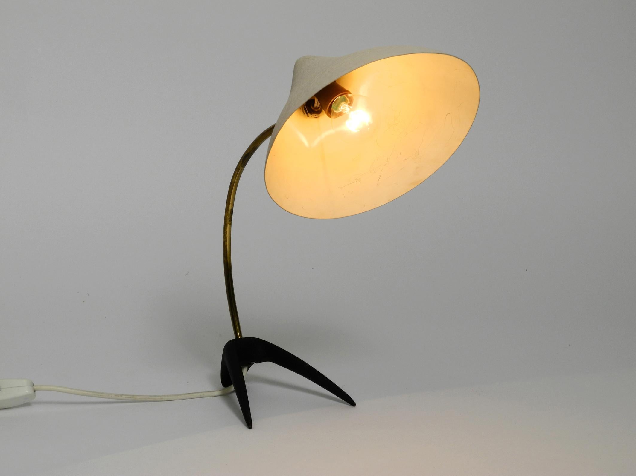 Rare beautiful Louis Kalff mid century crow's foot table lamp for Cosack.
Beautiful design with a movable cone lampshade.
Aluminum lampshade, brass neck and metal base with black shrink varnish.
Great patina with very minor signs of wear.
Slight