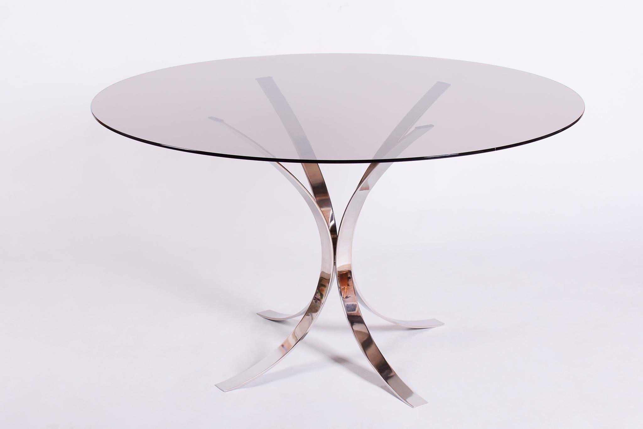 This elegant Mid-Century round dining table dates from the 1960s, hailing from Italy, and is a creation by the renowned designer Osvaldo Borsani.

The table features minimalist chrome-plated steel legs that lend the piece a light and modern