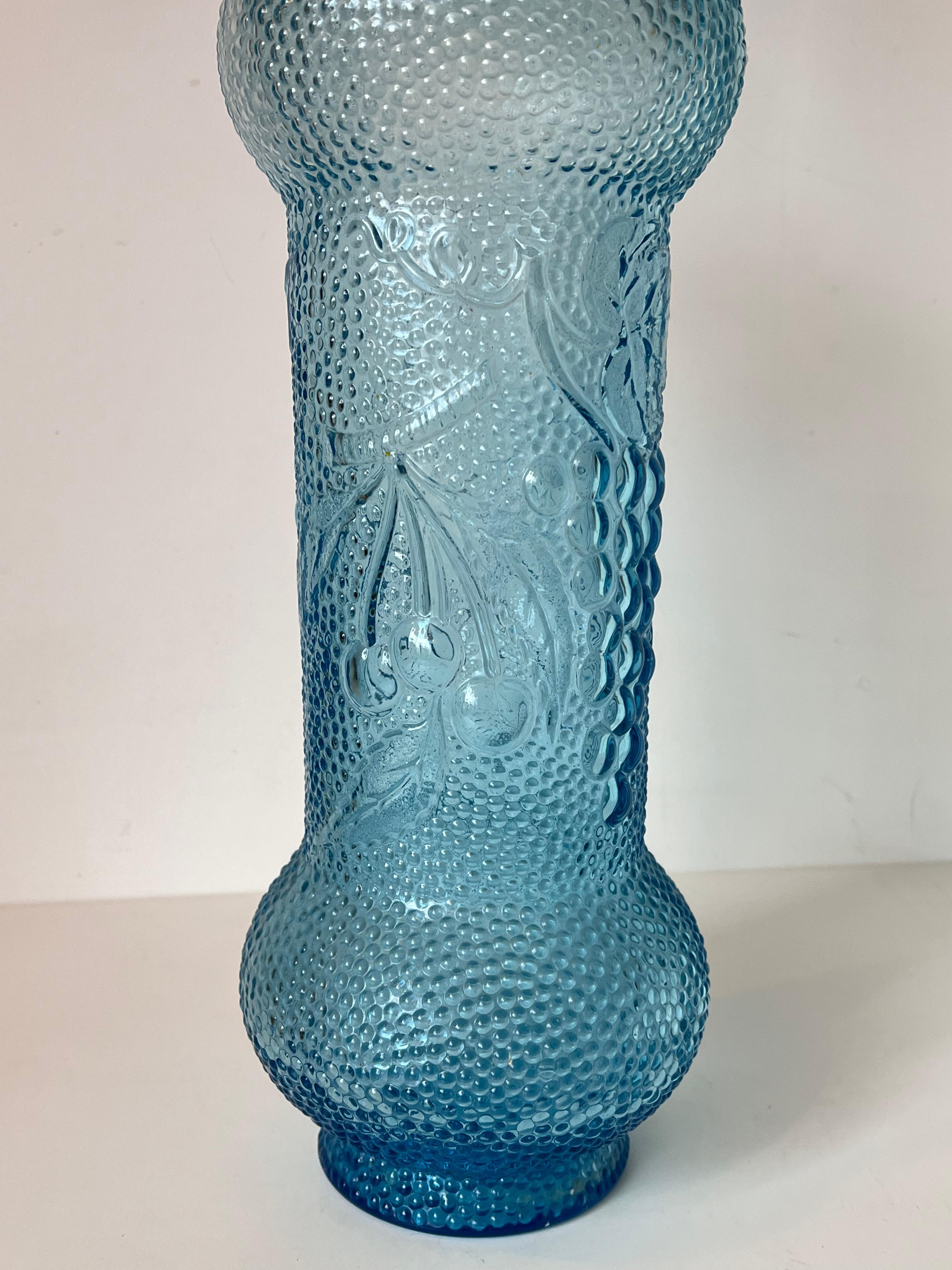 Aquablaue Vintage-Glaskaraffe, genannt Genie-Flasche. 
Aus Empoli, Italien, Mitte des letzten Jahrhunderts. 
Schöne Farbe und originelle Form, mit Früchten auf dem Bauch und tropfenförmigem Stopfen
Großes Format. 
In gutem Zustand!
 