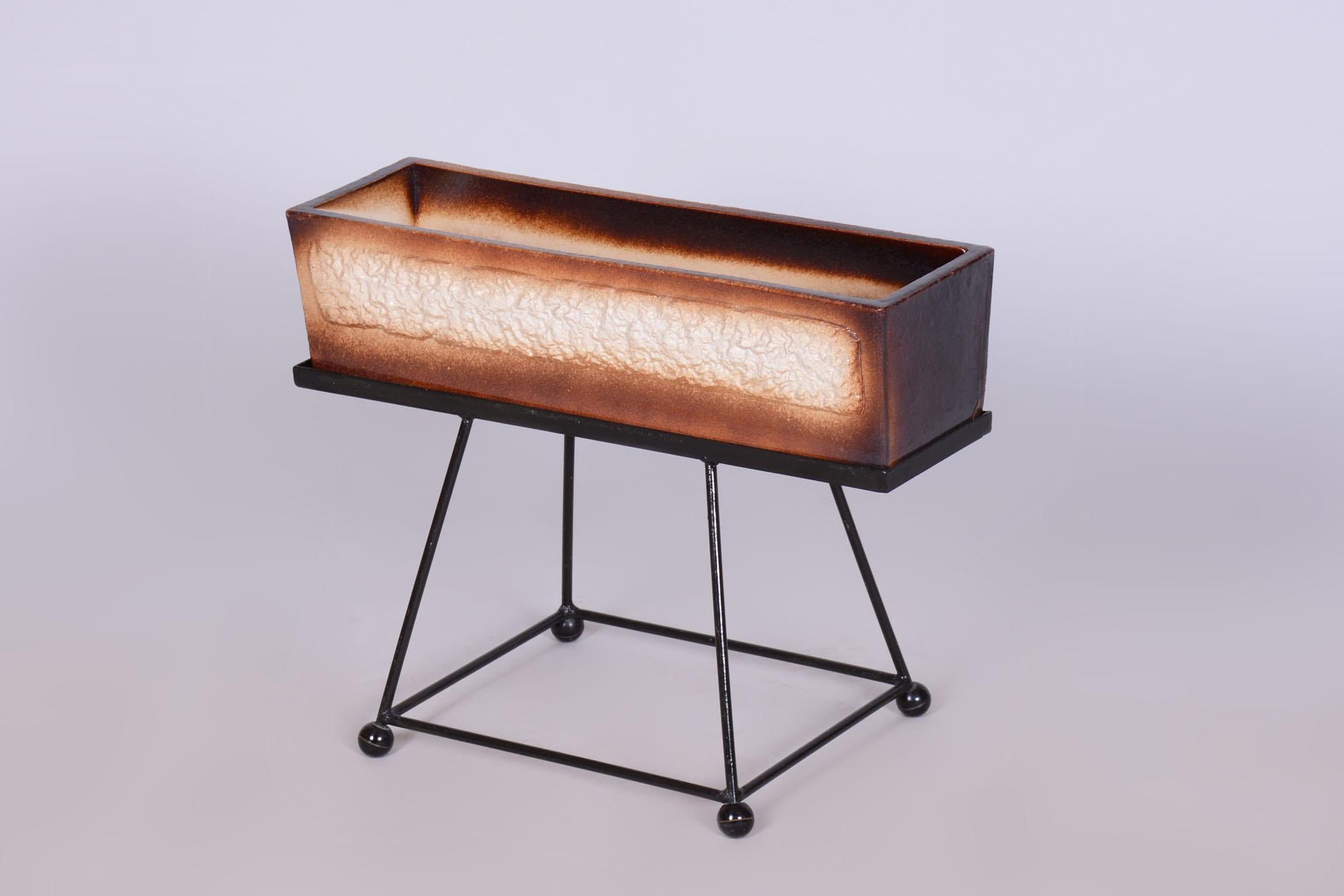 Cette élégante jardinière en céramique sur pied en acier est une pièce authentique du design du milieu du siècle en Tchécoslovaquie, datant des années 1960. Il incarne parfaitement la tendance de l'époque qui consiste à combiner des matériaux