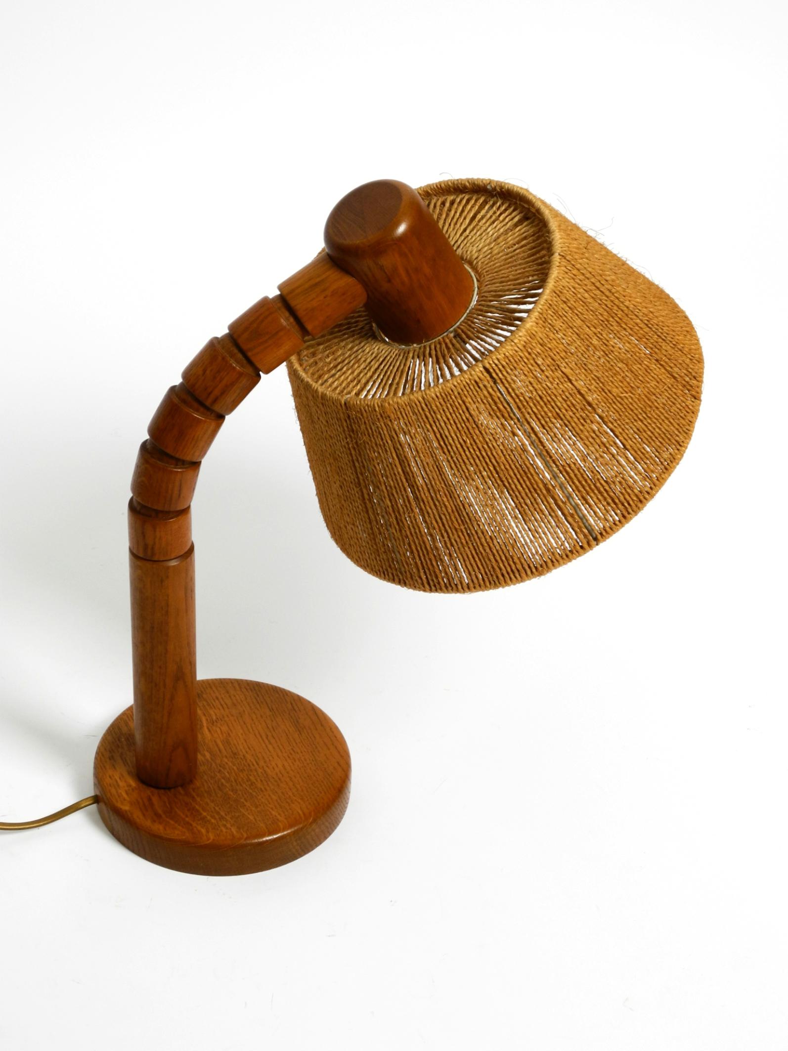 Very beautiful, very rare original 1960s table lamp by Temde, a German-Swiss lamp manufacturer.
The lampshade is made of sisal cord. The entire lamp is made of dark oak.
The neck is freely movable and holds firmly in any position.
The lamp is in a