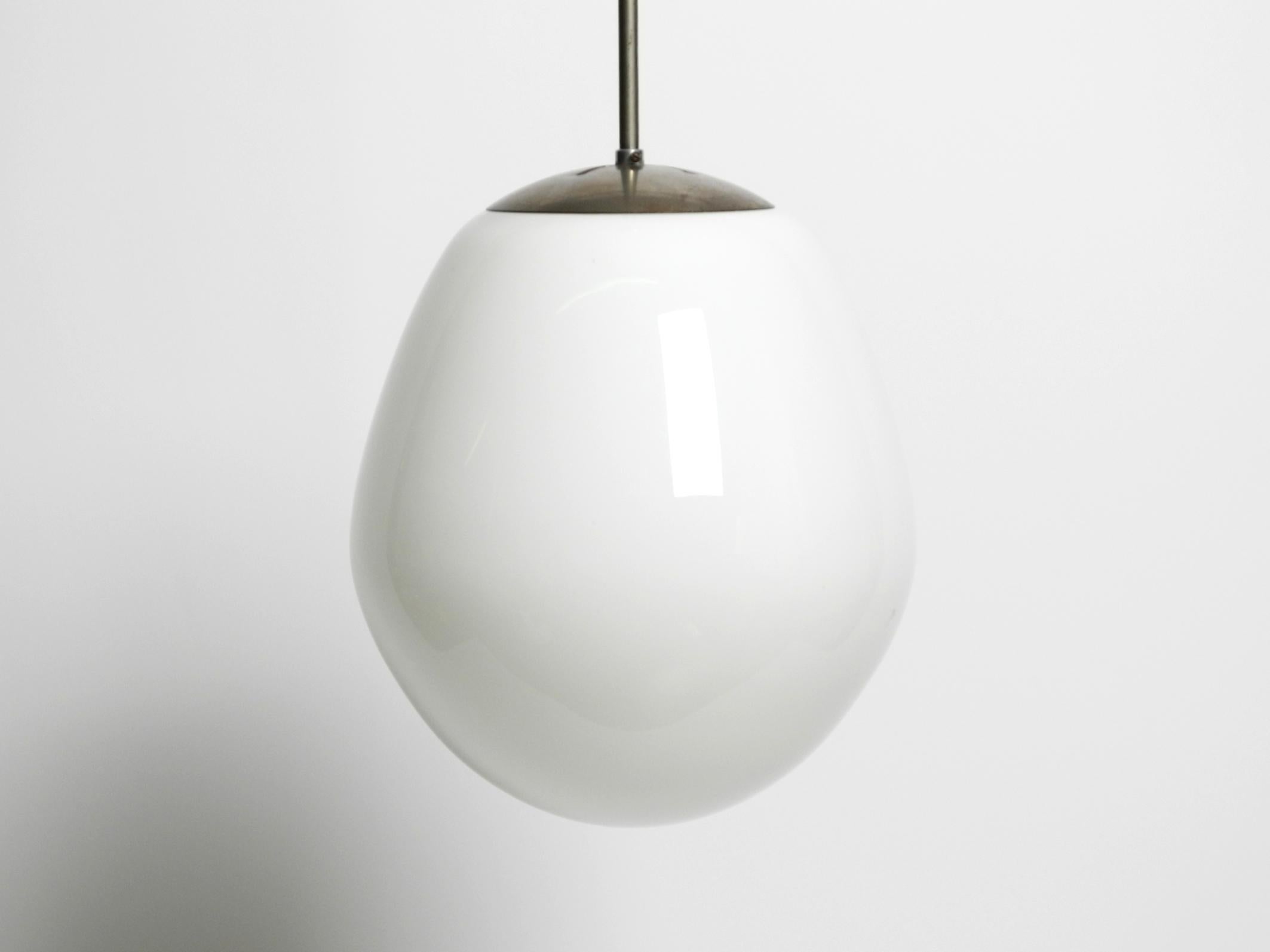 Bellissima lampada a sospensione in vetro Wagenfeld originale della metà del secolo scorso in XL.
Molto rara in questa versione grande con asta cromata.
Elegante design minimalista di Wilhelm Wagenfeld con un grande paralume in vetro opalino e una