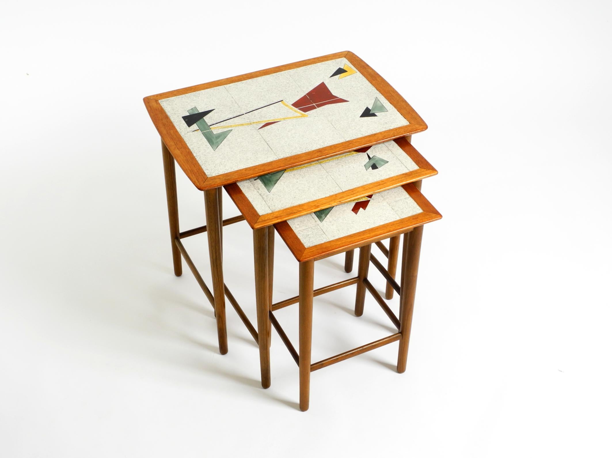 Original 1950s set of three teak side tables.
Formica tops with period-typical abstract graphic motifs.
Scandinavian production.
The undersides of the tables are made of pine.
A beautiful minimalist 1950s design in very good vintage condition.
The