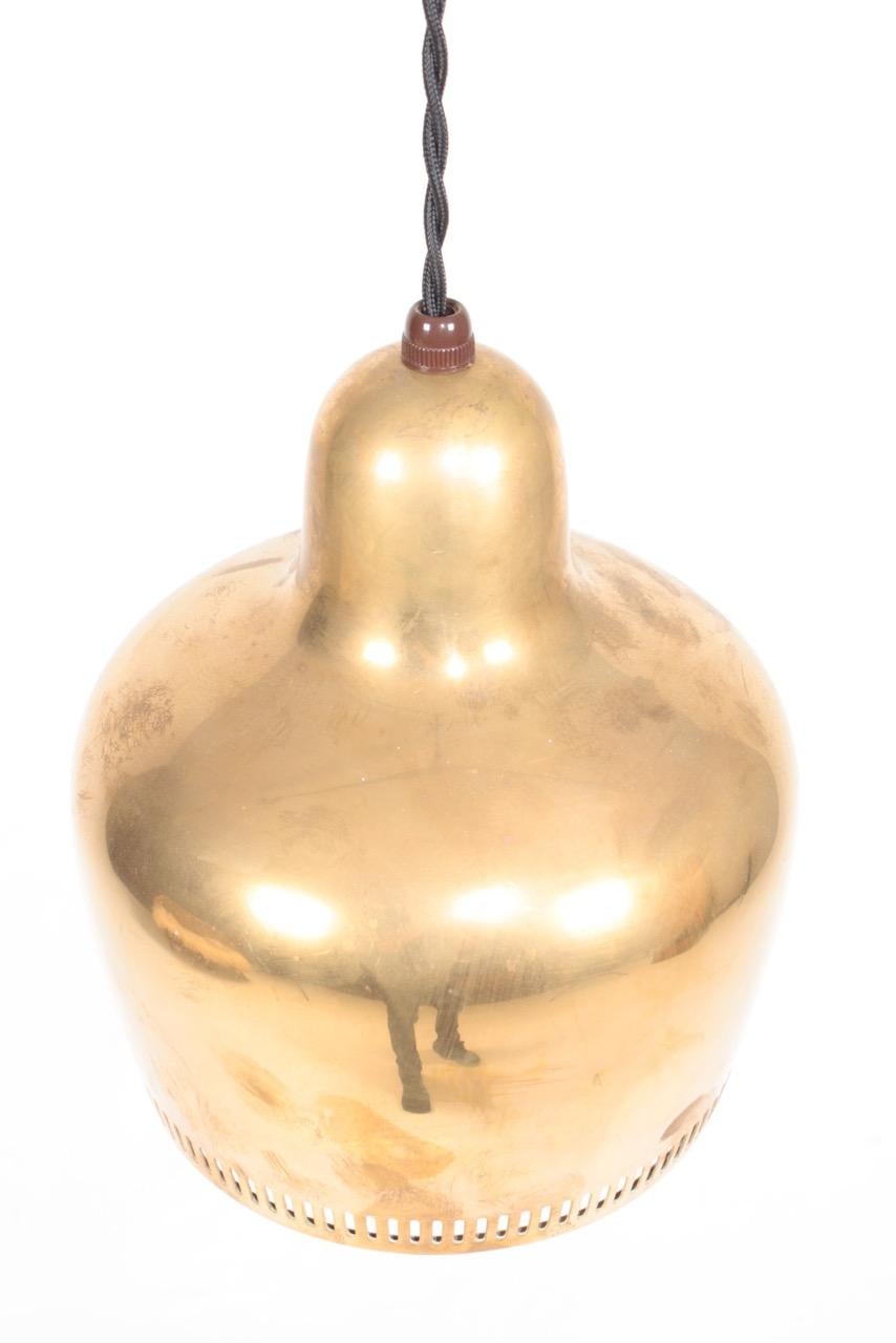 Pendentif en forme de cloche dorée en laiton patiné, conçu par Alvar Aalto pour Louis Poulsen en 1939. Fabriqué au Danemark. Excellent état.