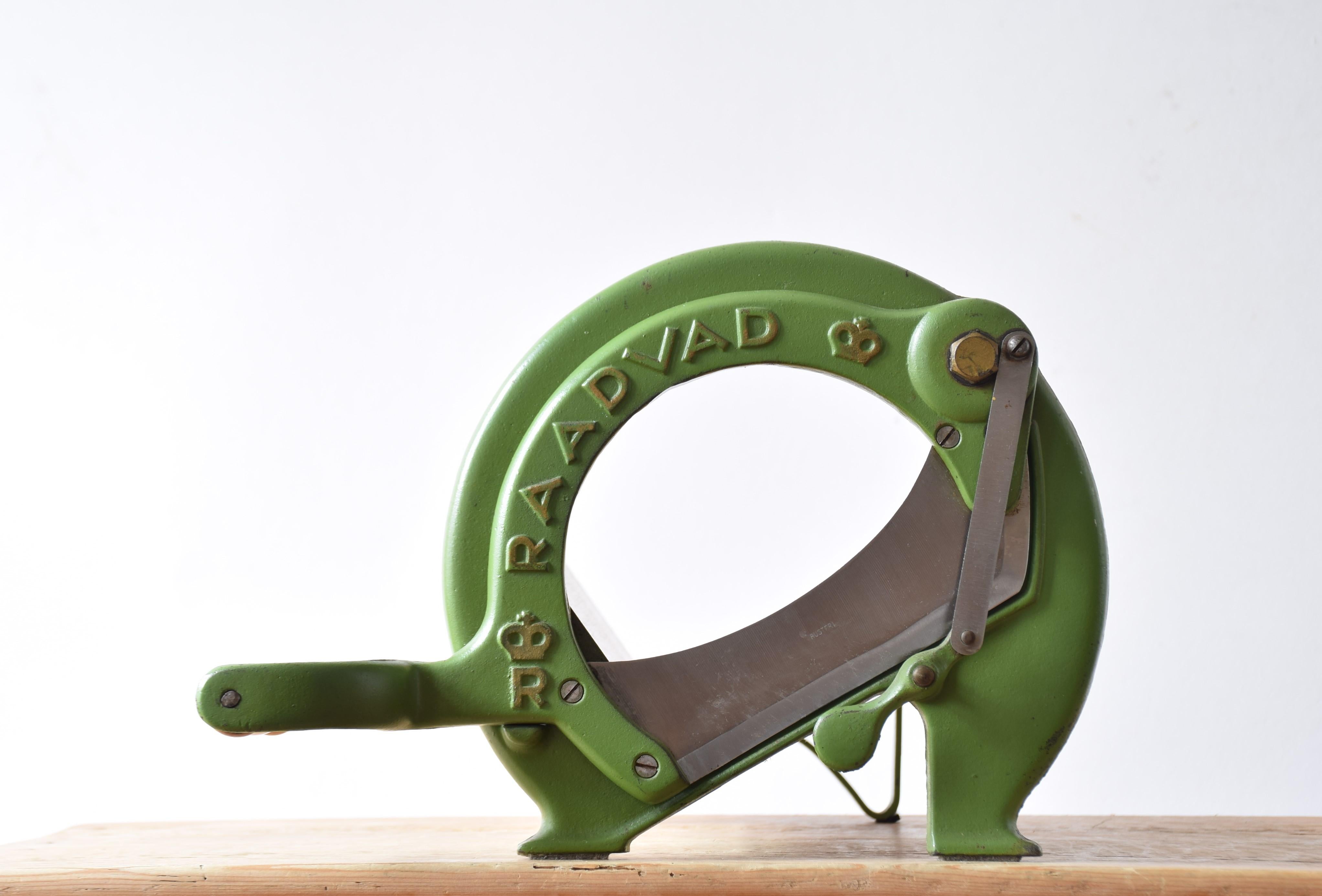 This iconic Danish bread slicer was produced by Raadvad in Denmark circa 1940s-1960s and designed in the 1930s. It comes with original green lacquer and still shows some of the original golden paint on letters and crowns. The bread slicer is fully