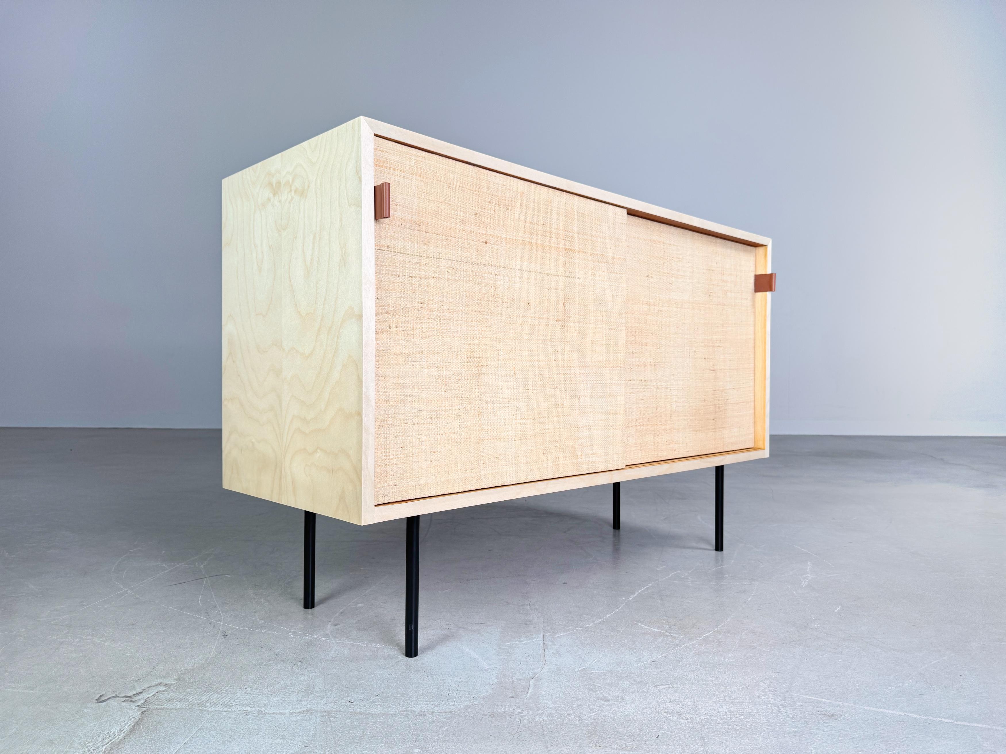 Wir bieten ein wunderschönes und sehr seltenes Sideboard aus den 1950er Jahren von Florence Knoll zum Verkauf an. Das Sideboard wurde von Knoll International hergestellt und verfügt über zwei Schiebetüren, die mit Seegras bespannt wurden, welches