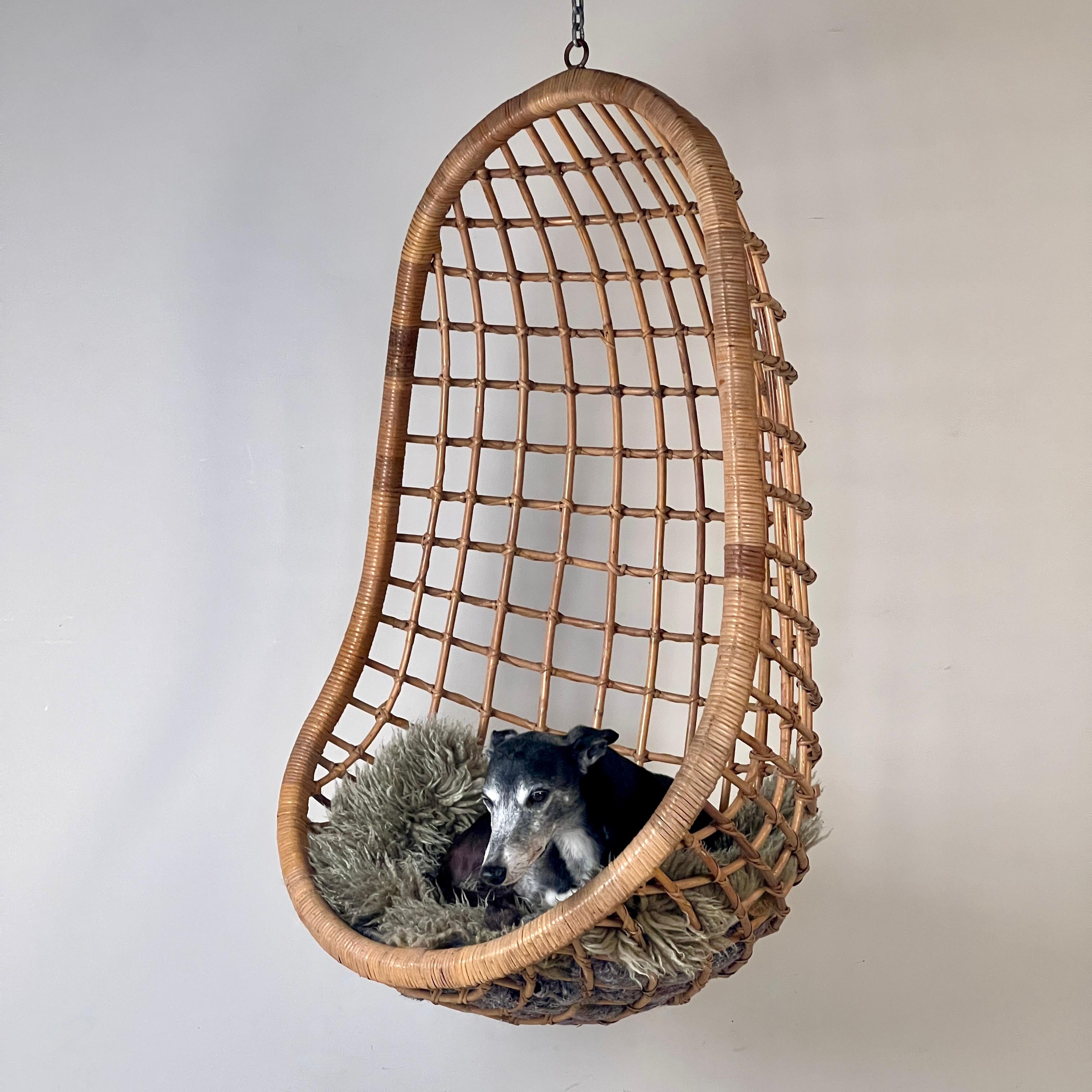 An original Midcentury Hanging Bamboo Egg Chair. This cool midcentury piece boasts a beautiful, natural patina that highlights its vintage charm. Made from durable bamboo with a beautiful organic shape, this hanging egg chair offers a cozy and