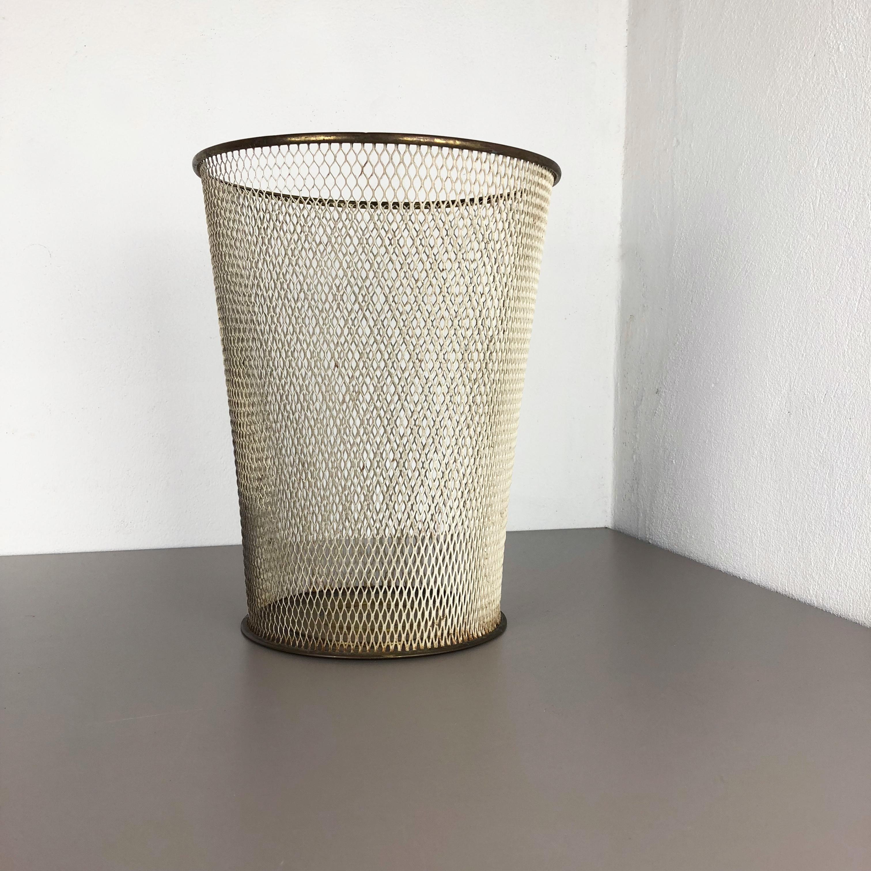 Article: Waste bin  paper bin
Origin: France
Age: 1950s

This original vintage Bauhaus style waste bin paper bin was produced in the 1950s in France. It is made of solid metal with brass applications at the top edge ring and bottom stand. this