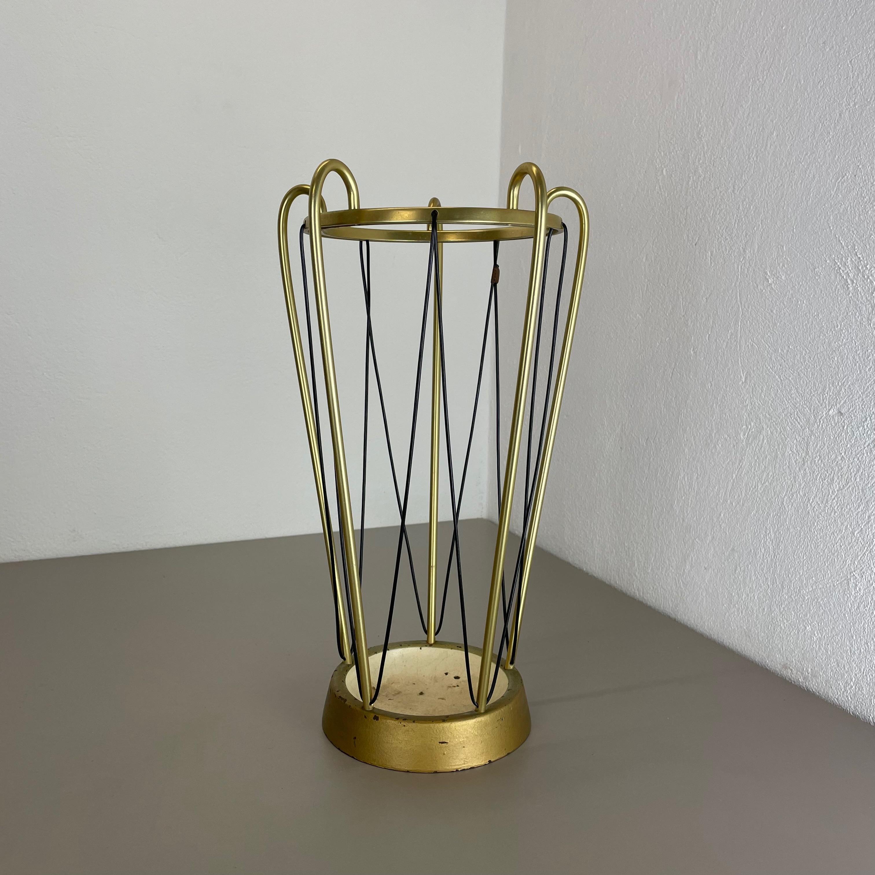 Article:

Bauhaus umbrella stand


Origin:

Germany


Age:

1950s


This original vintage Bauhaus style umbrella stand was produced in the 1950s in Germany. The brass colored top elements is made of aluminum the heavy metal base