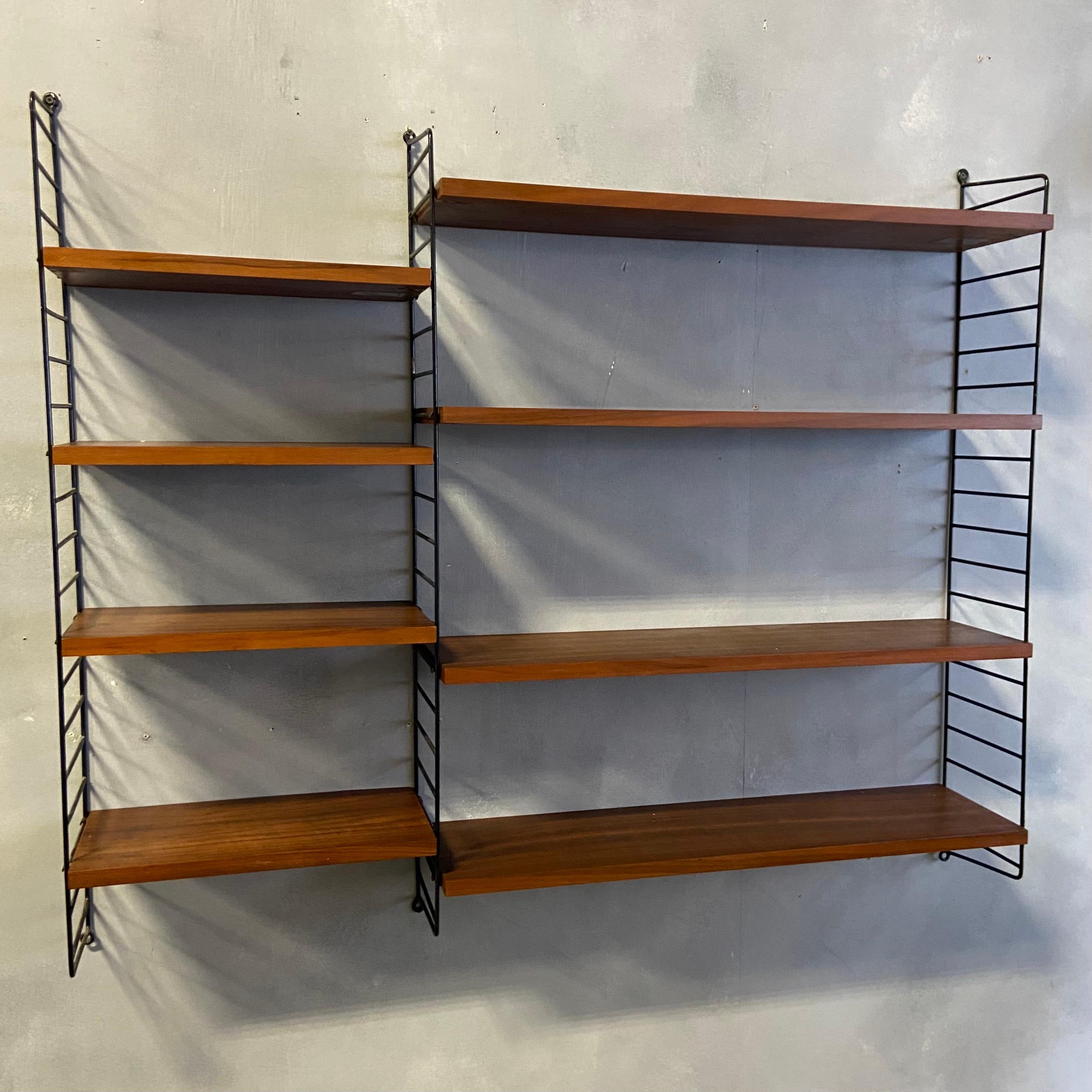 Beautiful Patina on this dark teak String Unit original from 1950. Featuring 8 shelves that are adjustable along the ladder work using the built in brass clips on each piece. This compact design would make an excellent small library, wall display,