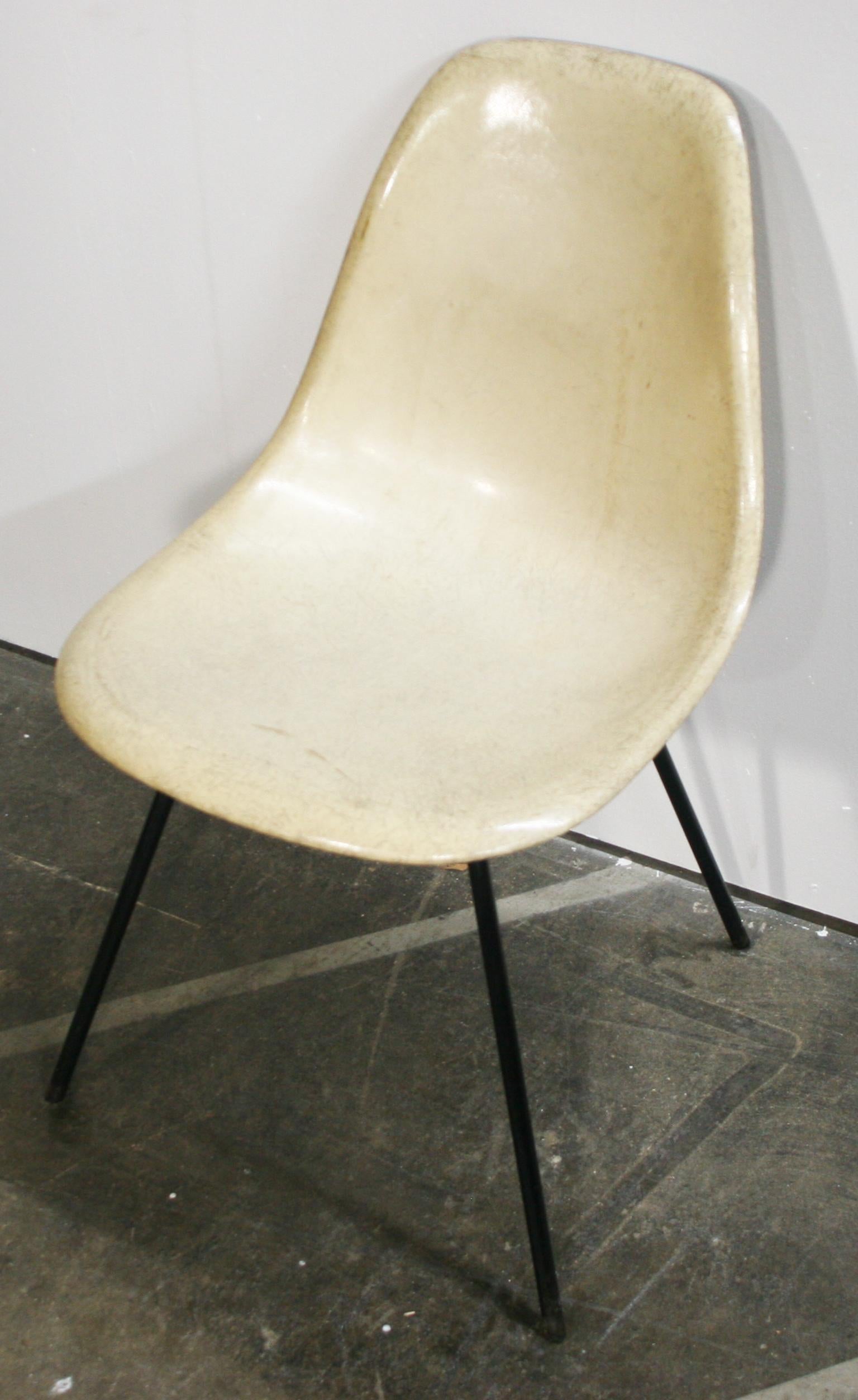 Original midcentury 1950s white Herman Miller fiberglass shell side chair iron X base. Very rare chair. Bone white shell. Flat head screws. Original good vintage condition. All shock mounts are good. Designer Charles Eames.