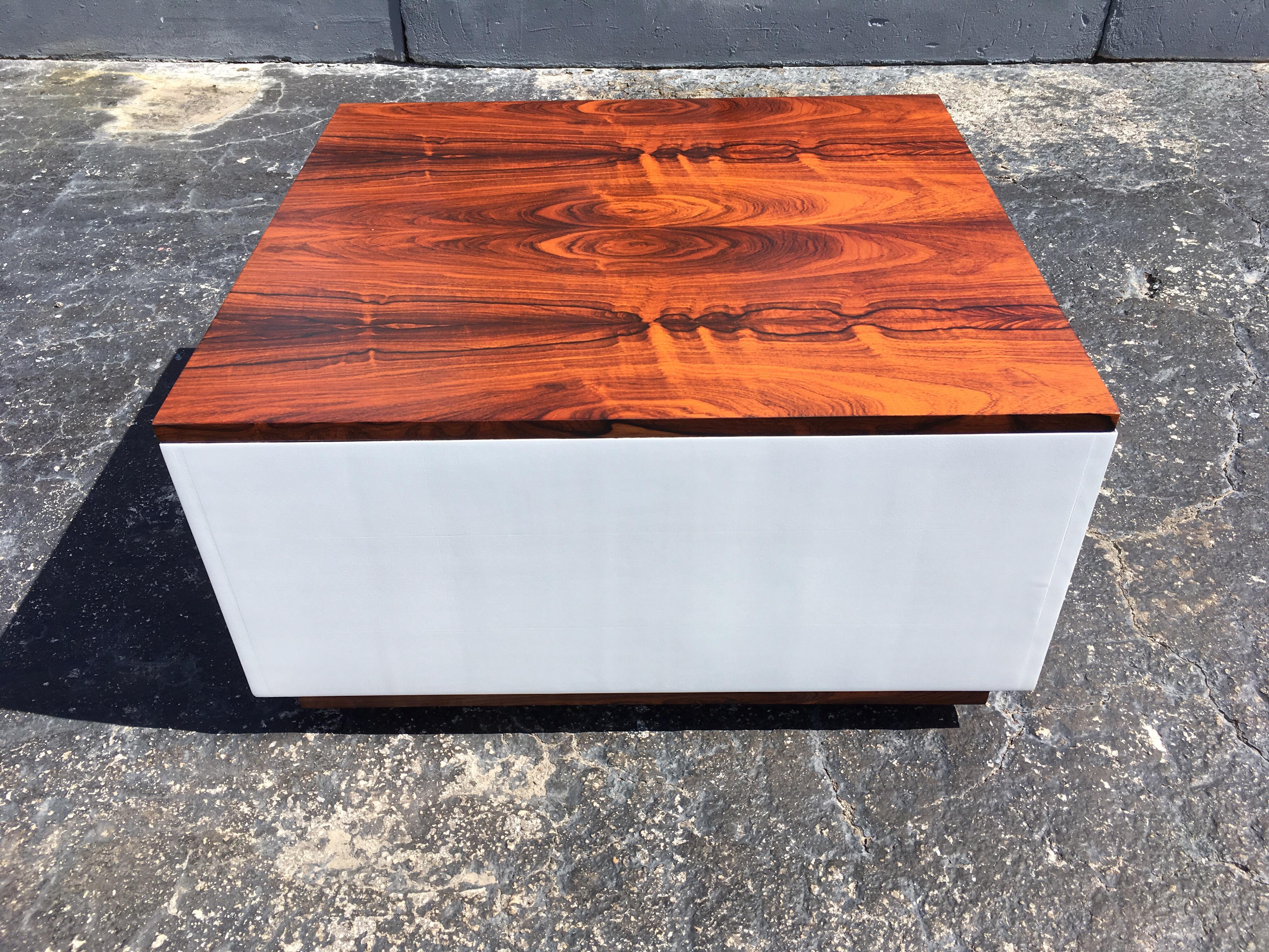 Signed Milo Baughman table, rosewood top and base white painted sides. The top of this piece features a lifting surface that opens to reveal a hidden compartment perfect for tucking away clutter. The table has casters.