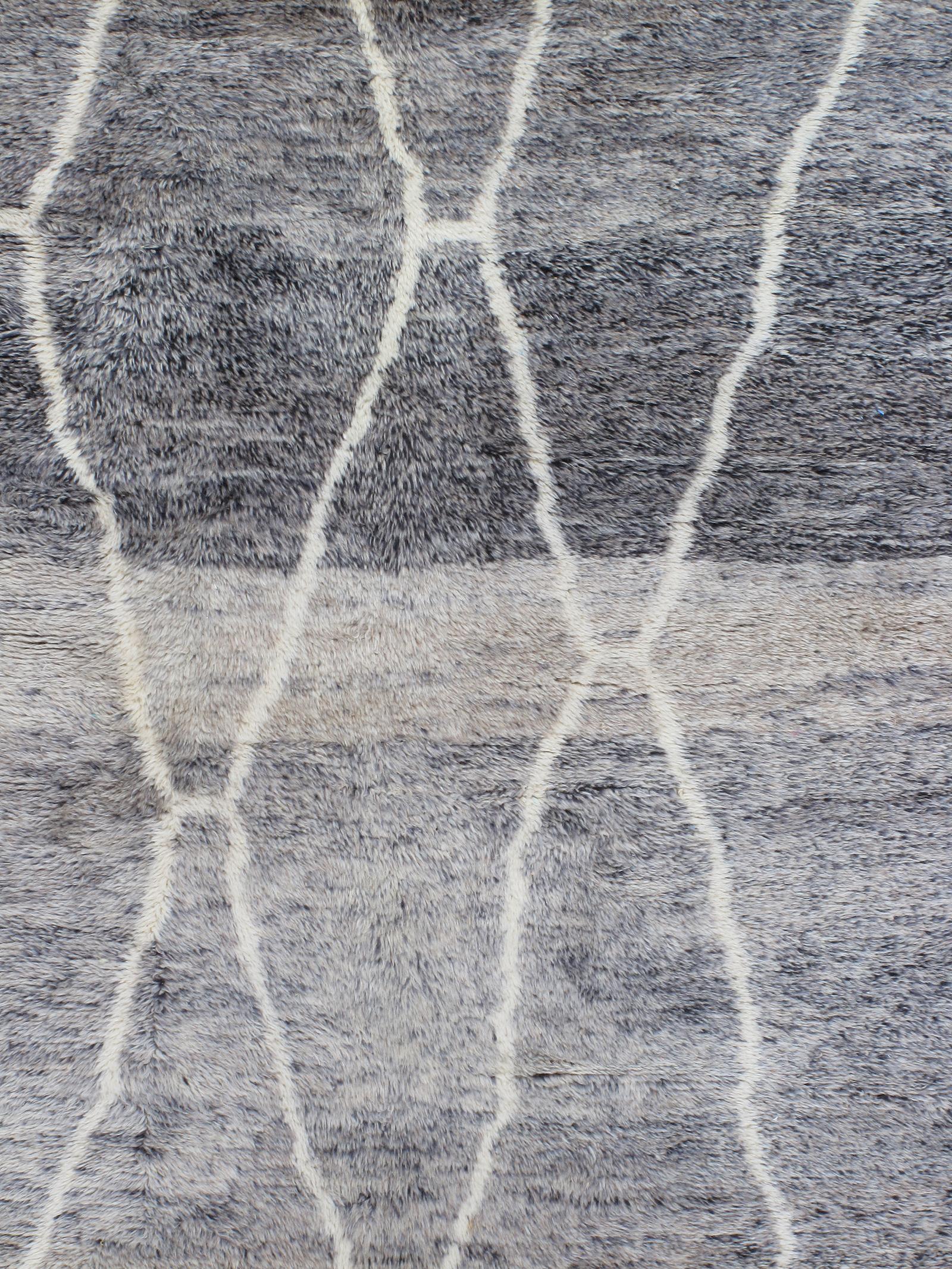Esta original alfombra marroquí sigue el estilo de las alfombras Beni Ourain, fabricadas durante siglos por las tribus nómadas bereberes del norte de África. Las alfombras Beni Ourain se identifican por sus líneas geométricas que forman un dibujo