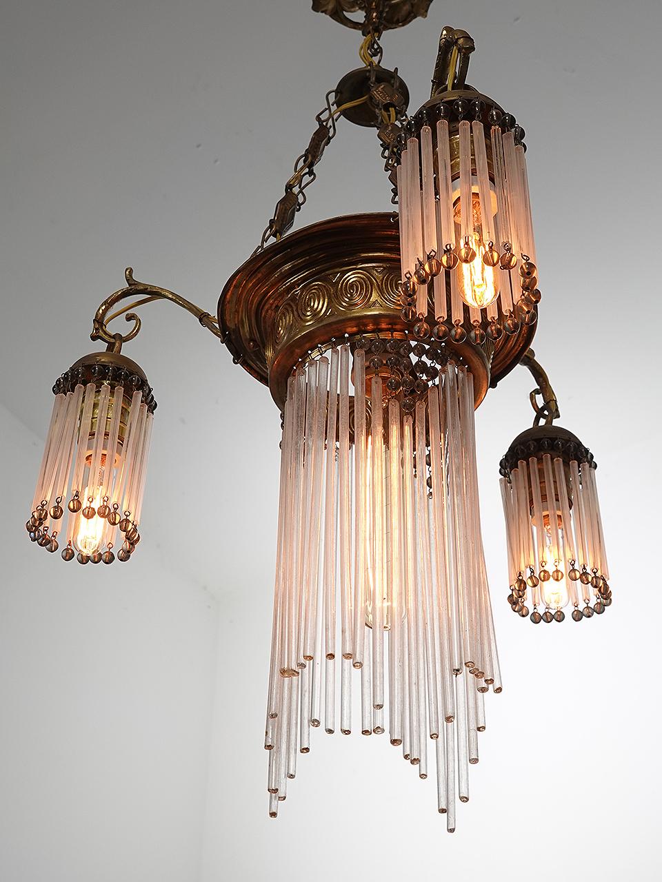 You can call this delicate lamp Jugendstil or Art Nouveau and the look is amazing. The style is very distinctive. This lamp has all of its hand blown hollow glass rods with no damage, and there are over 100 of them. The decorative embossed metal