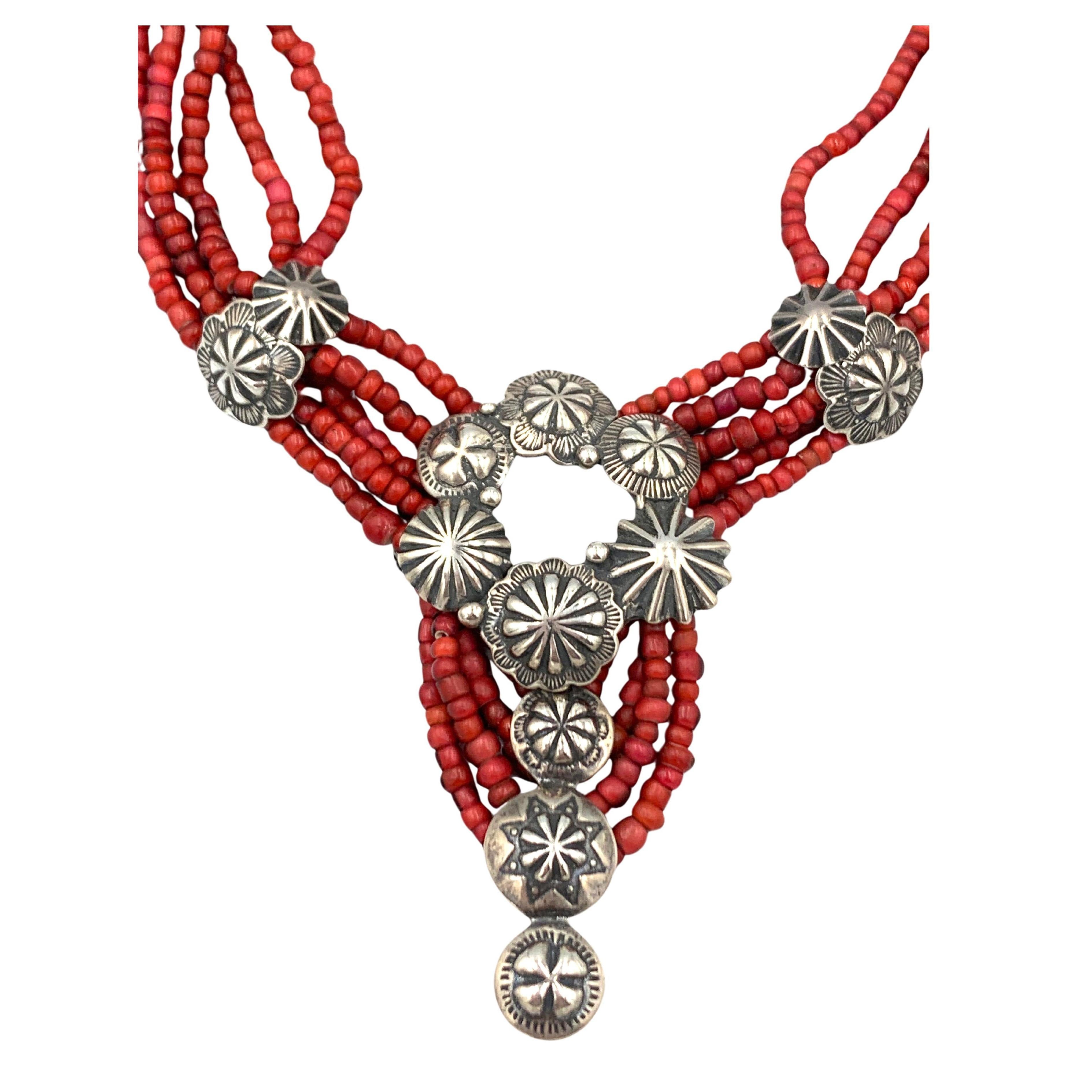 Il cerchio di un bottone Navajo in sterlina, il penzolo e i lati sono sospesi da perline di vetro rosso (cuore bianco) provenienti dall'Africa. - descrizione originale scritta a mano da Mary Hancocks

Mary e Doug Hancocks, di Mummy's Bundle, creano