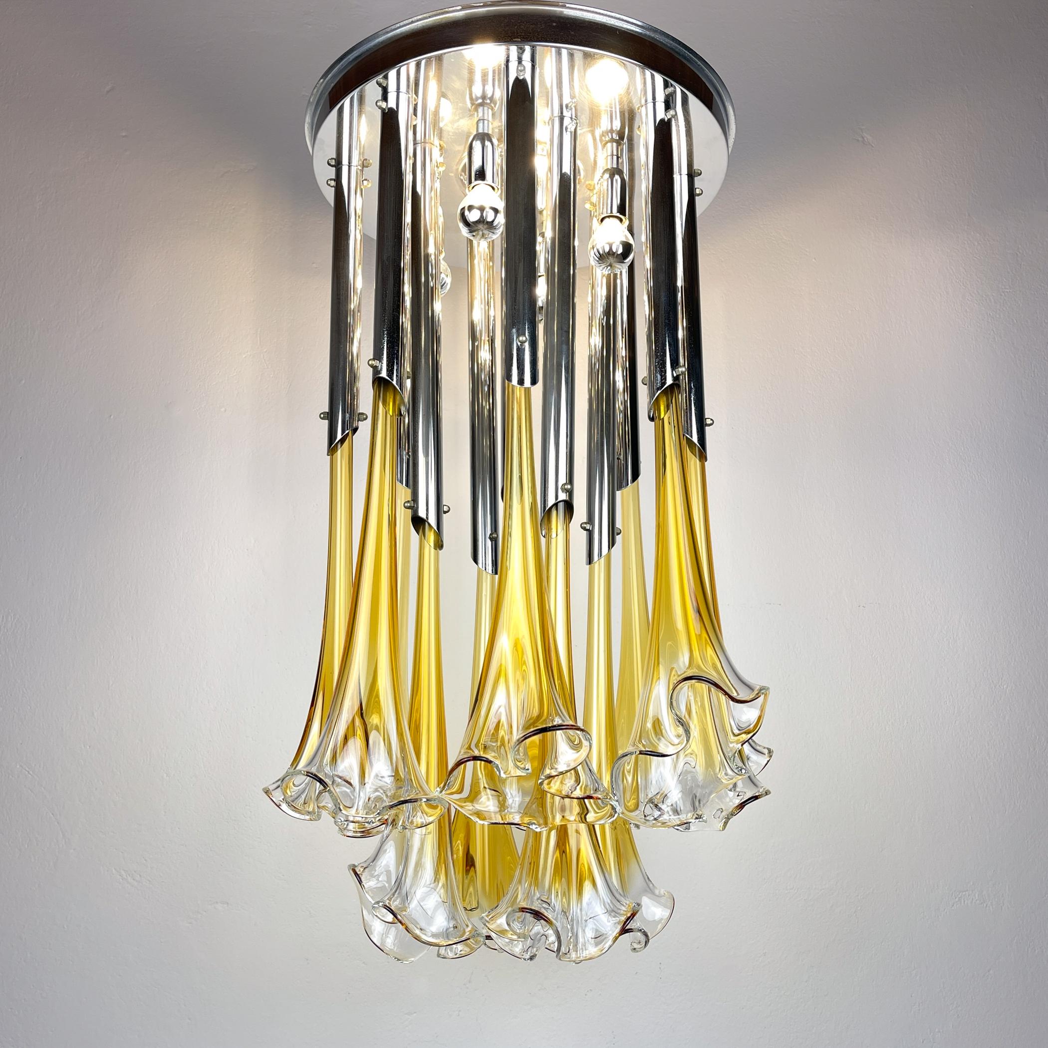 Il lampadario di Murano Calla o Lily di Venini, unico nel suo genere, è stato realizzato in Italia negli anni Sessanta. Bellissimo lampadario con fiori di vetro che sembrano cadere da un supporto cromato. Questa lampada dal design straordinario è un