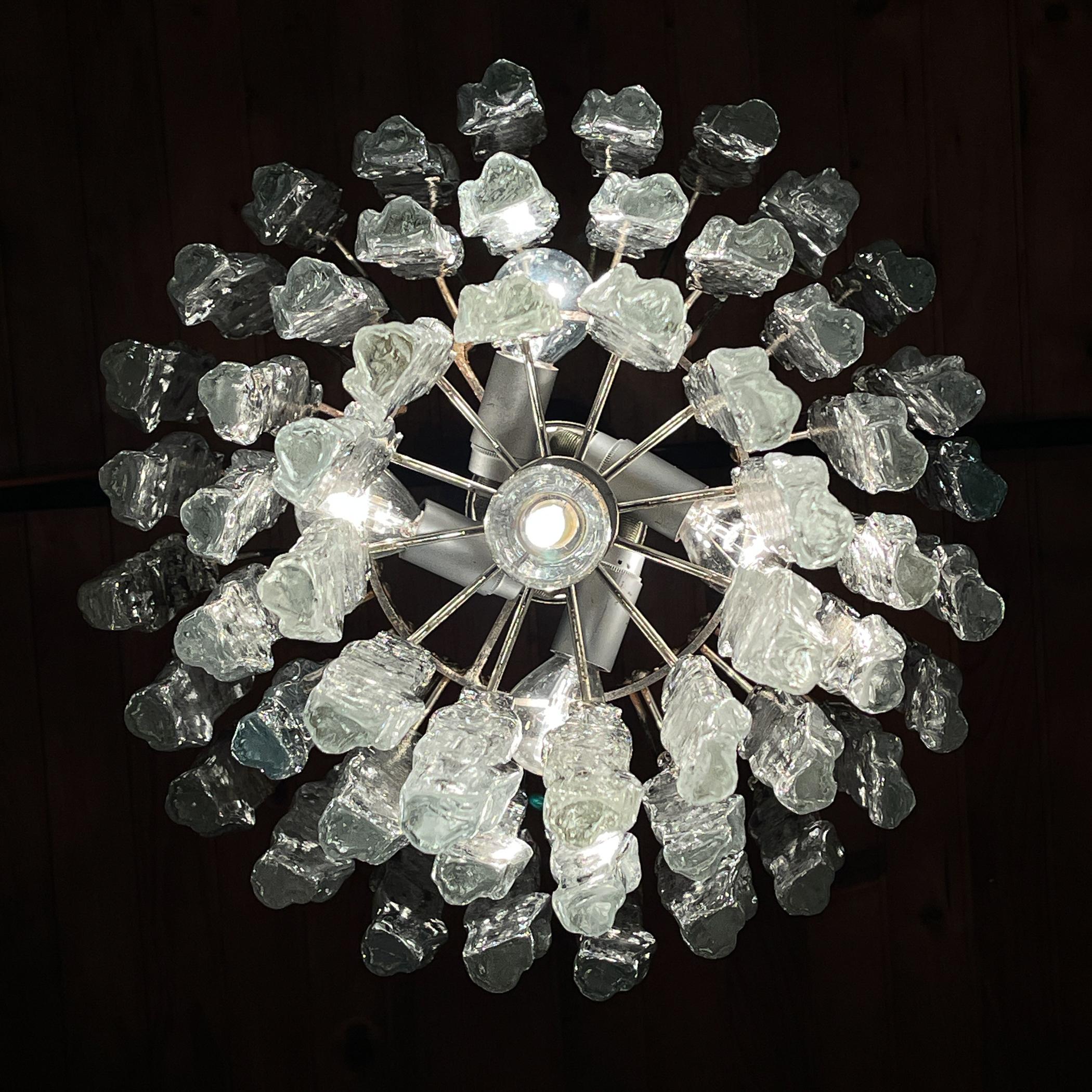 Incredibile lampadario Kalmar originale d'epoca con pendenti in vetro spesso e strutturato, ognuno dei quali assomiglia a ghiaccioli allungati. Vetro fatto a mano, montatura in metallo con patina naturale. Austria, anni '70.
Questo modello era